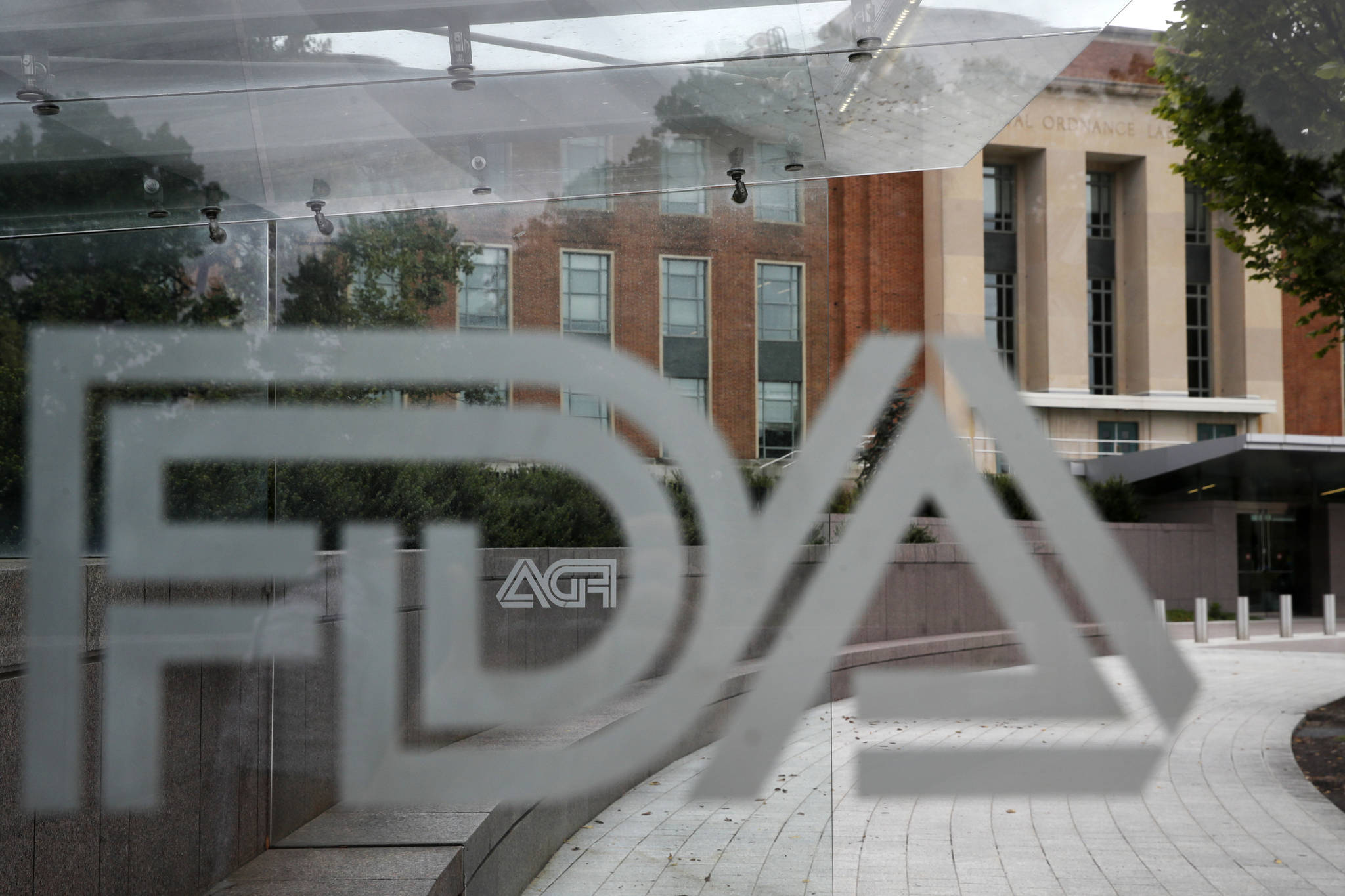 This photo shows the U.S. Food and Drug Administration building behind FDA logos at a bus stop on the agency’s campus in Silver Spring, Md. U.S. regulators have approved a new type of coronavirus test that administration officials have touted as a key to opening up the country. The Food and Drug Administration on Saturday, May 9, 2020, announced emergency authorization for antigen tests developed by Quidel Corp. of San Diego. The test can rapidly detect fragments of virus proteins in samples collected from swabs inside the nasal cavity, the FDA said in a statement. (AP Photo/Jacquelyn Martin, File)
