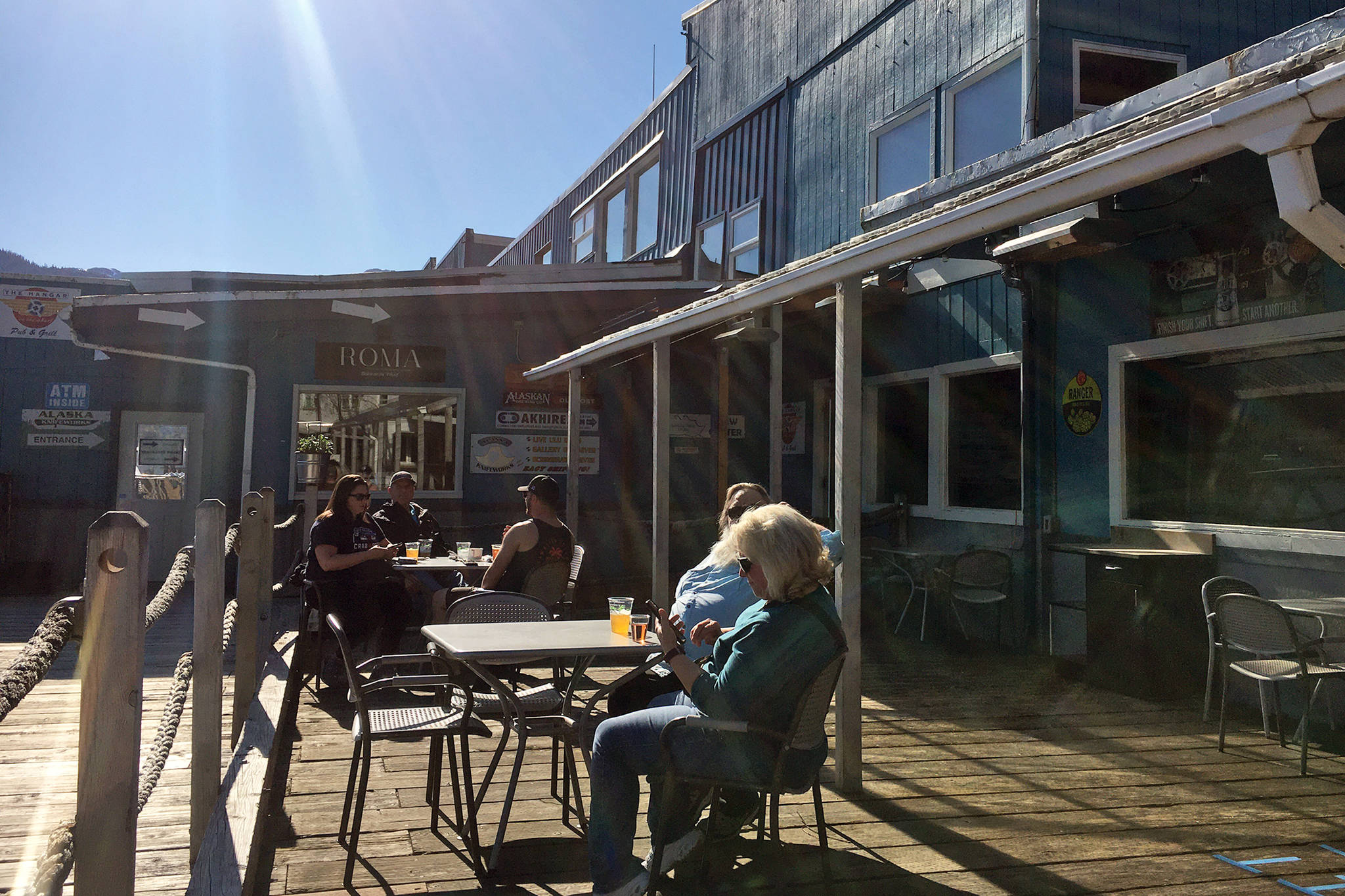 People get drinks and sun at the Flight Deck, Thursday, May 21. Restaurants are among the businesses able to open to 100% capacity as of Friday although many business owners and managers said they intend to proceed slowly. (Michael S. Lockett | Juneau Empire)