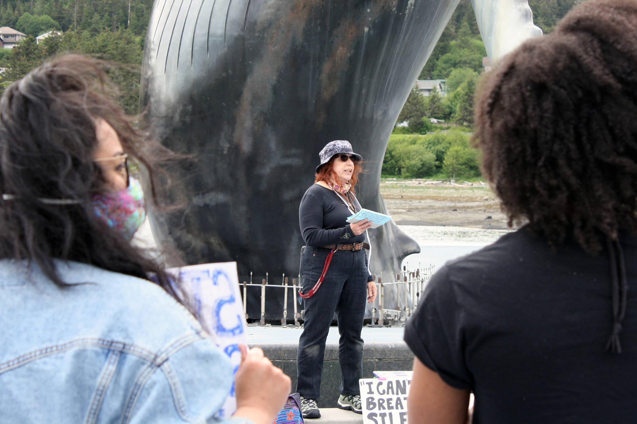 Christianne Carrillo and Jennifer Gross listen while Gloria Merry talks to begin the “I Can’t Breathe” vigil held Saturday, May 30 at Mayor Bill Overstreet Park. Most attendees wore masks, many brought protest signs, and the event was peaceful. (Ben Hohenstatt | Juneau Empire)