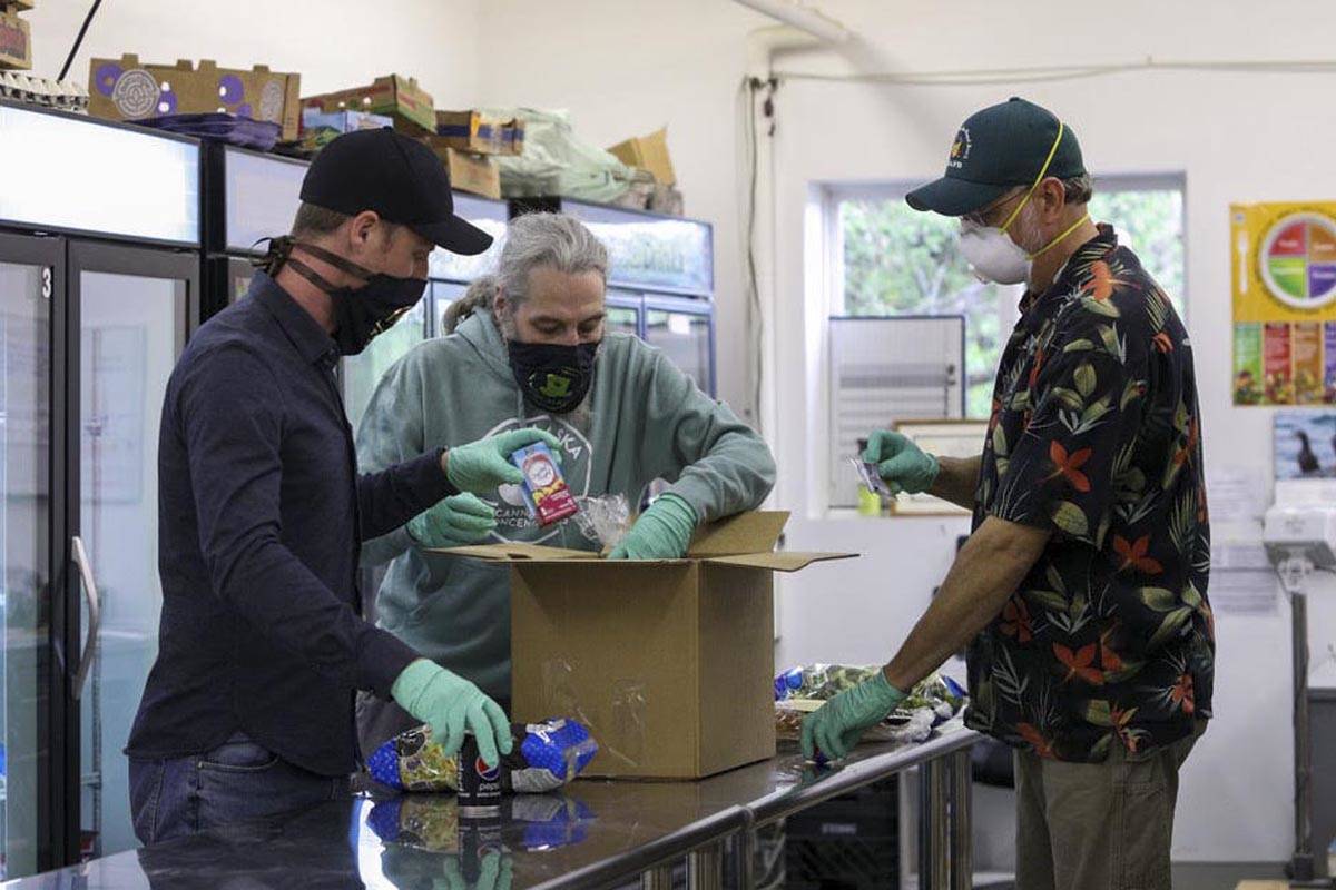 John Nemeth and Ben Wilcox with Top Hat Cannabis, left, pack boxes with Southeast Alaska Food Bank manager Chris Schapp on Friday, May 29, 2020. Top Hat Cannabis donated $10,000 to the food bank to support operations during the onging coronavirus epidemic. (Courtesy photo | John Nemeth)