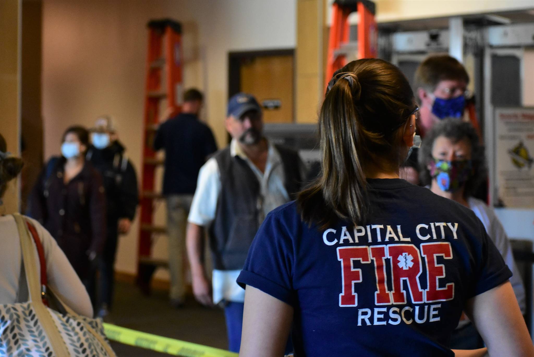 A member of Capital City Fire/Rescue’s Airport Screening Task Force greets passengers disembarking from a flight arriving at the Juneau International Airport on Wednesday, May 27, 2020. (Peter Segall | Juneau Empire)