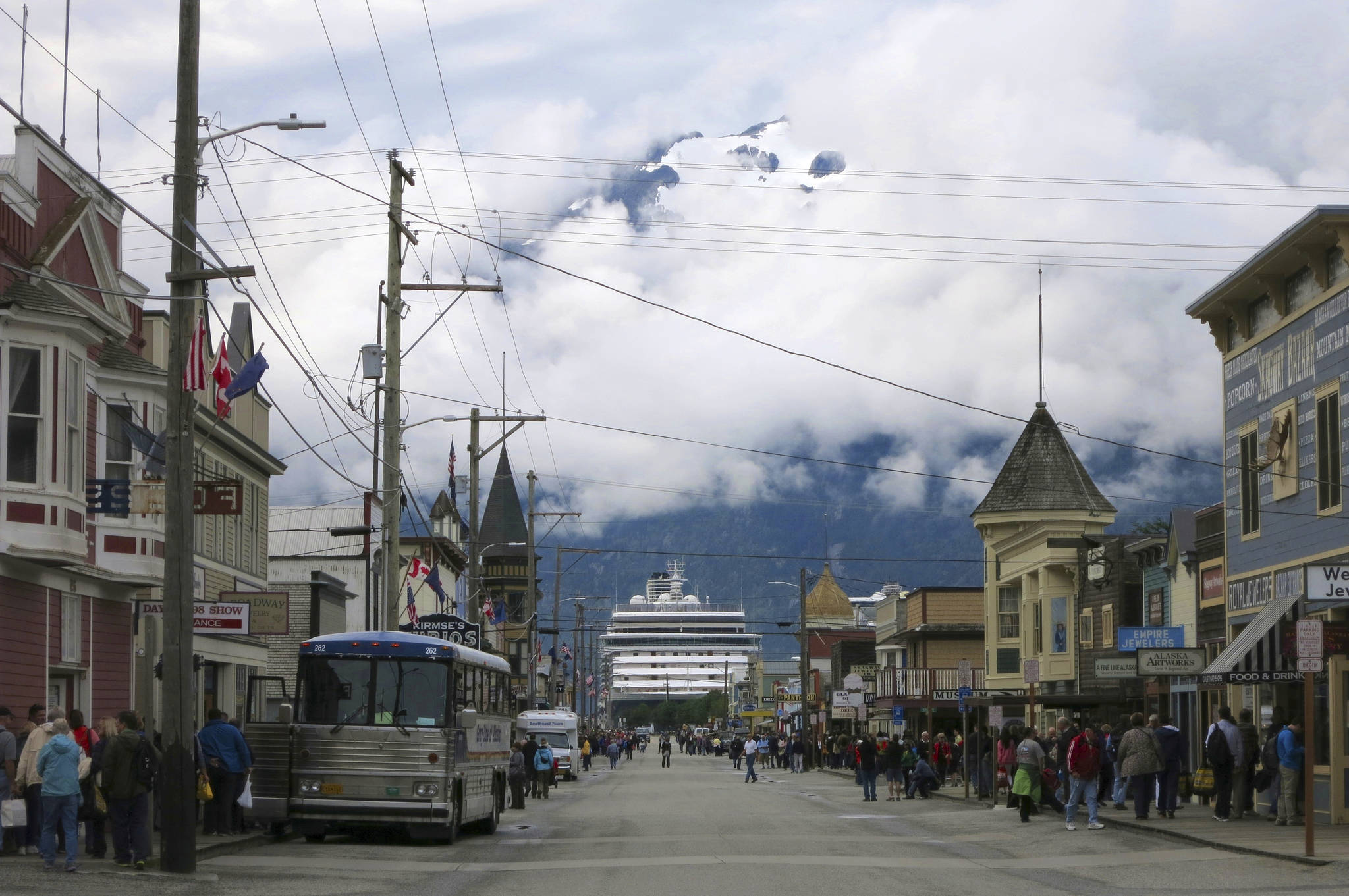 This July 2014 photo shows a cruise ship docked in Skagway, Alaska, as passengers tour the town. The Alaska port city, nearly entirely dependent upon cruise ship tourism, wants to share its federal coronavirus relief funds with workers in town. The city of Skagway posted an application on its website inviting residents to apply for up to $1,000 in relief funds to help with bills. Nearly half of Alaska’s 2.2 million tourists arrive on cruise ships, but most companies have canceled their summer seasons, leaving workers here without much relief. (AP Photo | Kathy Matheson)
