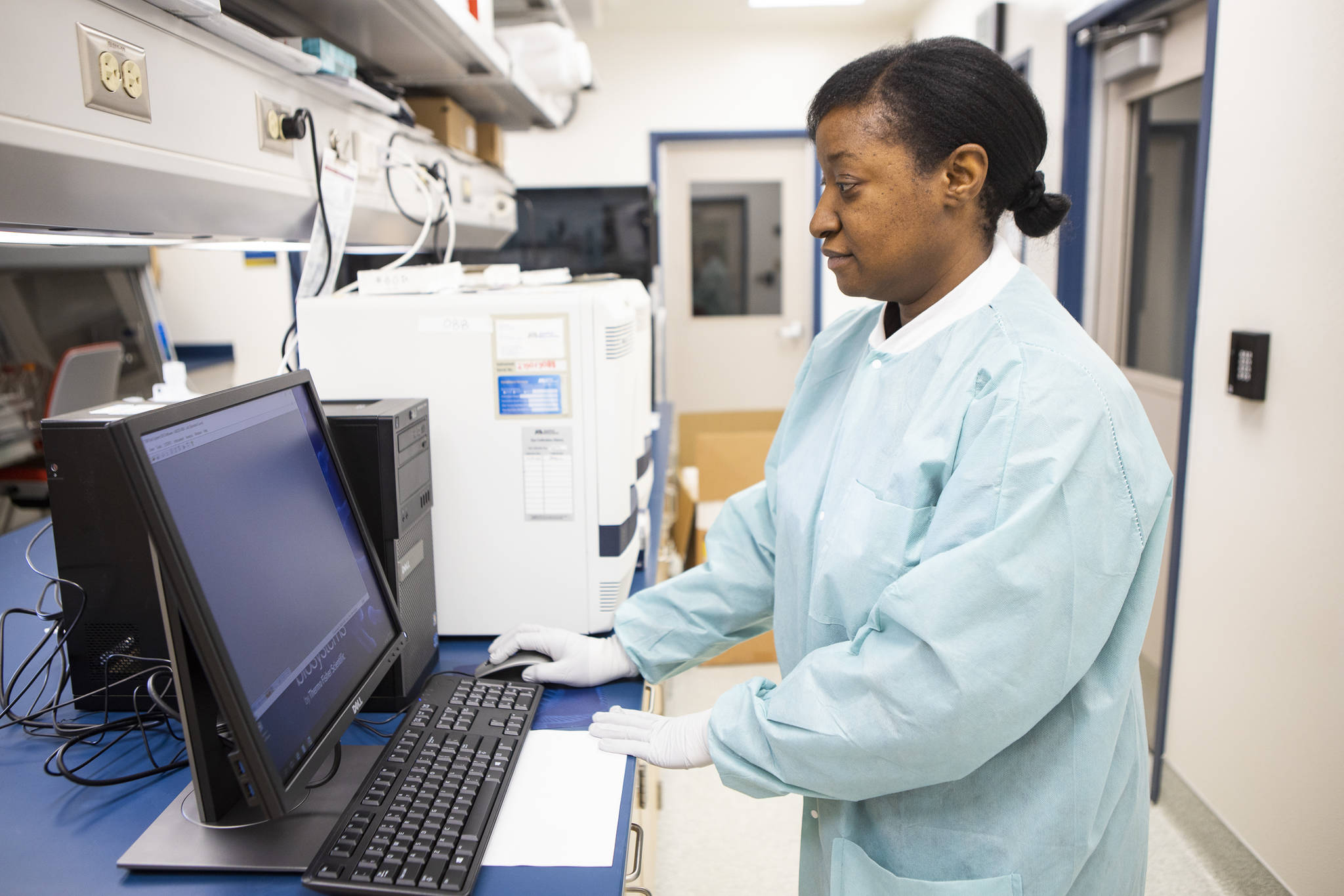 Public health microbiologist and molecular diagnostics section lead Nisha Fowler loads a tray of samples into the thermal cycler to test for COVID-19 virus at the Alaska State Virology Laboratory in Fairbanks. City and Borough of Juneau is considering purchasing a machine that would allow the city to process COVID-19 tests locally. ( J.R. Ancheta | University of Alaska Fairbanks)