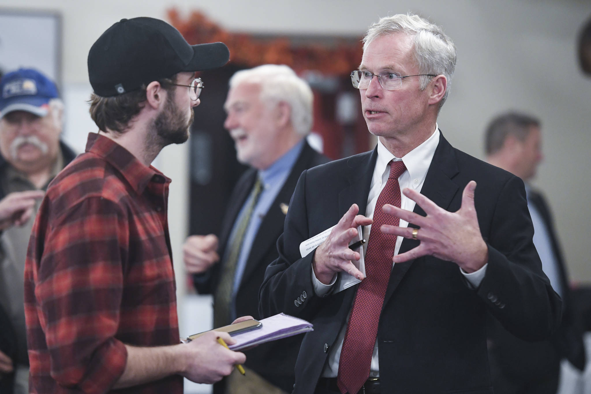 In this November 2019 photo, Jim Johnsen, president of the University of Alaska, is questioned by Kieran Poulson-Edwards, a writer for the Whalesong, the student newspaper at the University of Alaska Southeast, after Johnsen’s speech at the Juneau Chamber of Commerce at the Moose Lodge. (Michael Penn | Juneau Empire File)