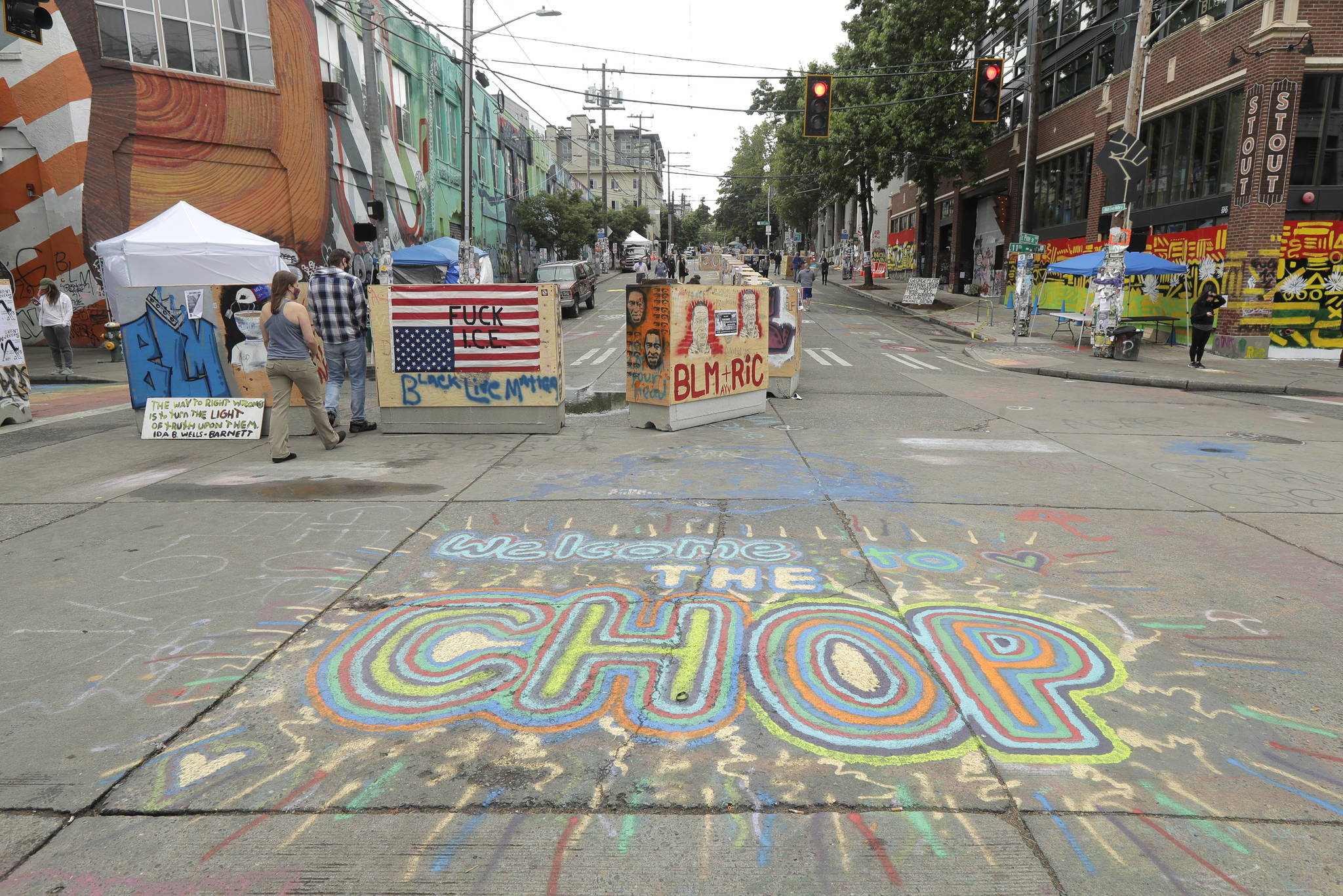 A sign on the street reads “Welcome to the CHOP,” Saturday, June 20, 2020, inside what has been named the Capitol Hill Occupied Protest zone in Seattle. A pre-dawn shooting near the area left one person dead and critically injured another person, authorities said Saturday. The area has been occupied by protesters after Seattle Police pulled back from several blocks of the city’s Capitol Hill neighborhood near the Police Department’s East Precinct building. (AP Photo/Ted S. Warren)