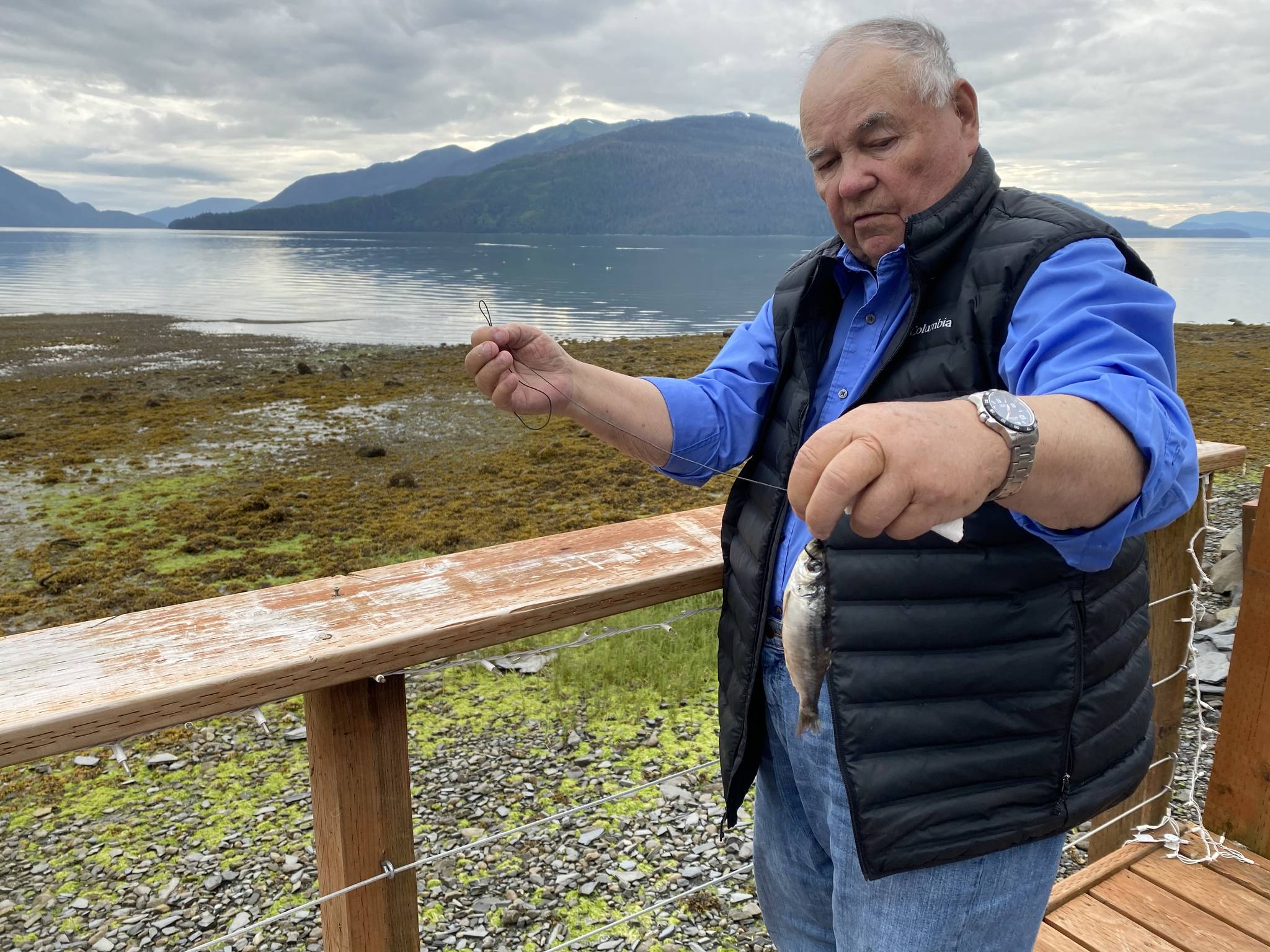 Mickey Prescott demonstrates how to choke a herring. He says choking a herring is a troller term used in the old days. He learned this technique from his dad. (Vivian Faith Prescott | For the Capital City Weekly)