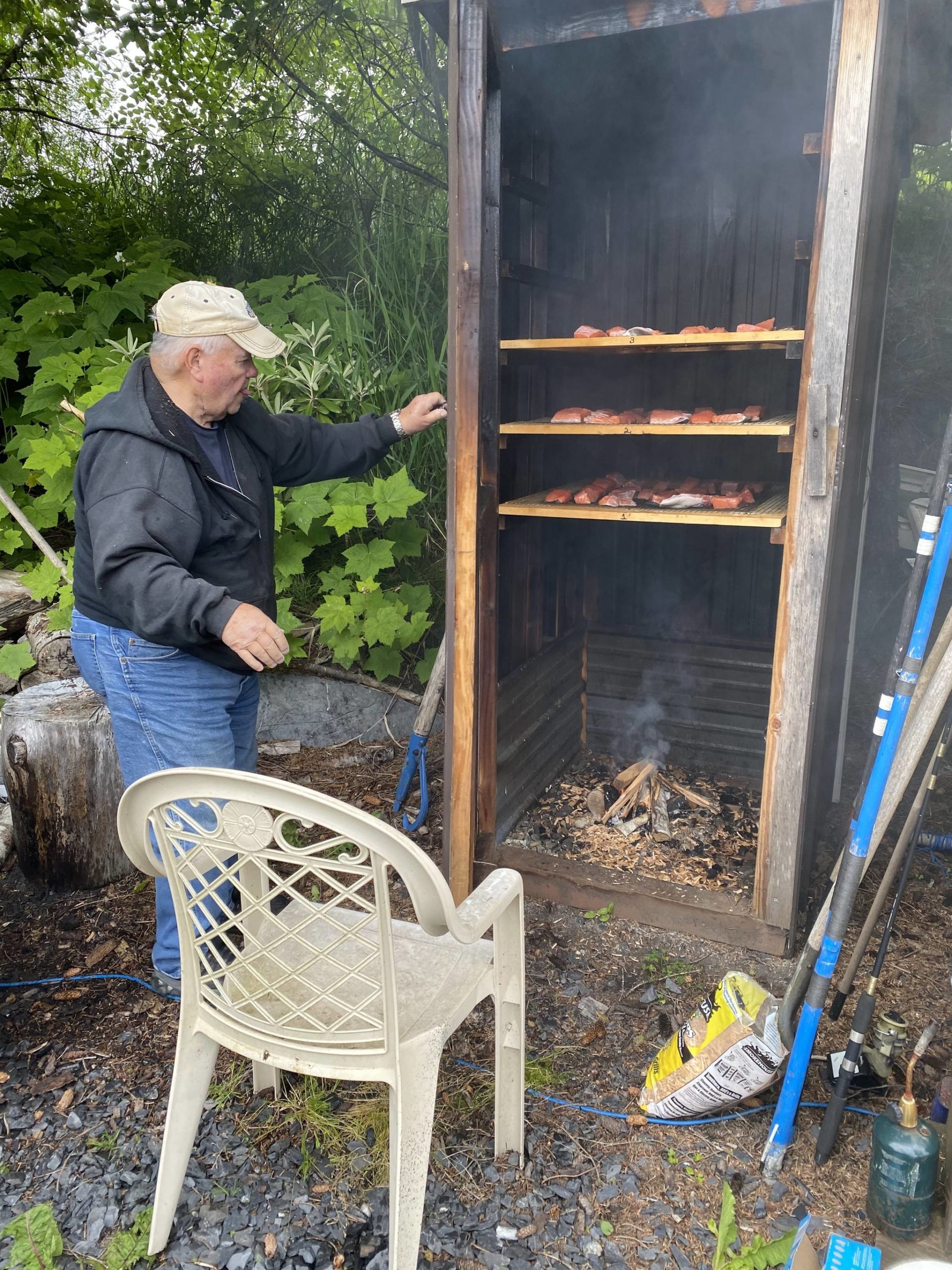 Mickey Prescott checks on the smoked salmon in Wrangell. (Vivian Faith Prescott | For the Capital City Weekly)