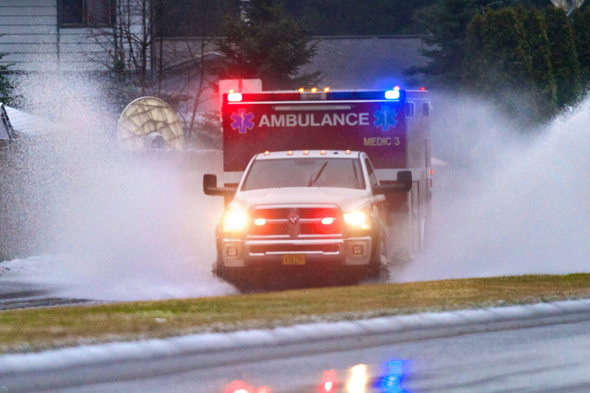 A Capital City Fire/Rescue ambulance splashes through a flooding area of Riverside Drive on their way to a call in this January 2015 photo. (Michael Penn | Juneau Empire File)