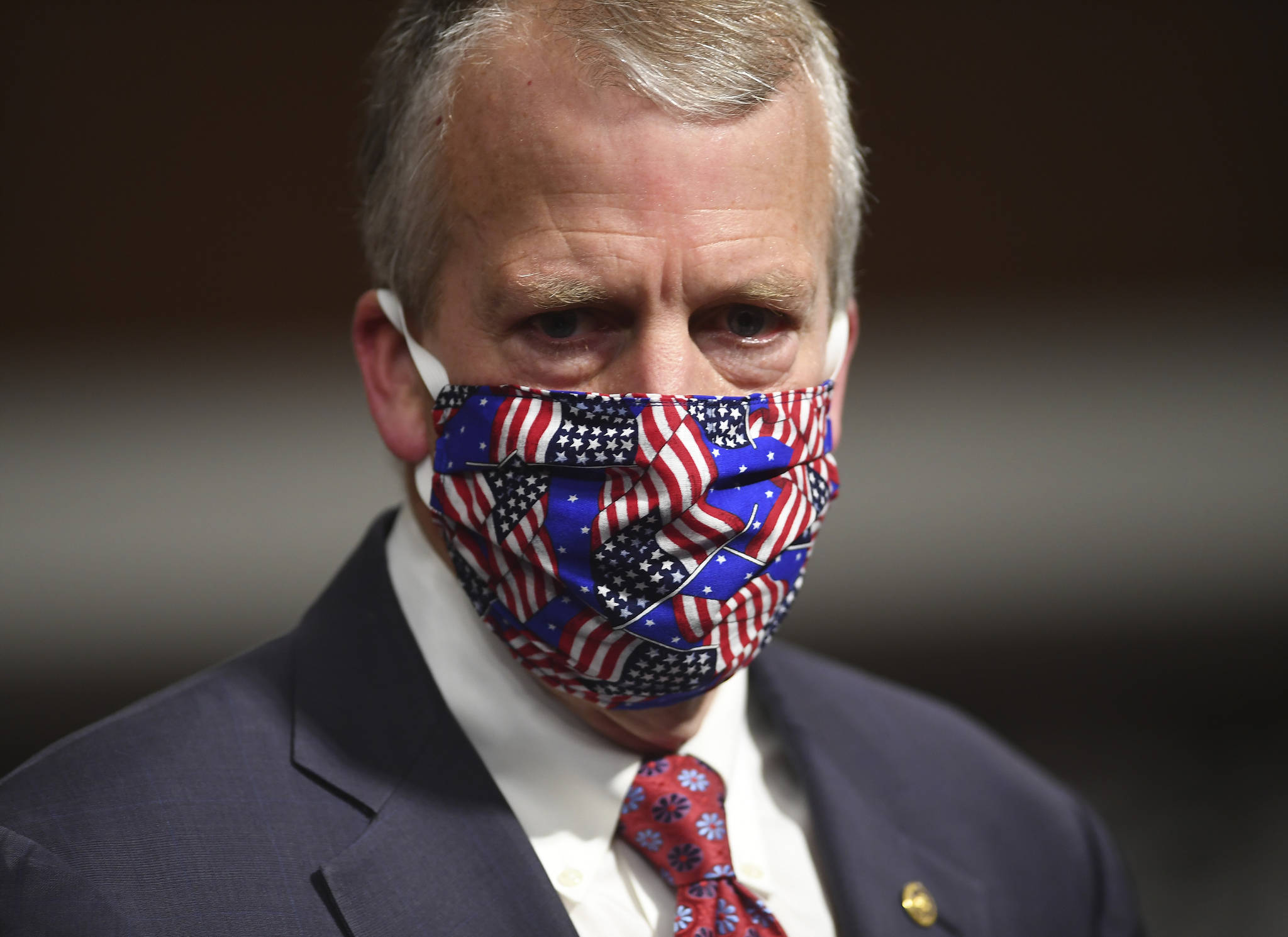 In this May 7 photo, Sen. Dan Sullivan wears a mask at a hearing in Washington. Protesters in Alaska carrying a banner and a caribou heart interrupted a campaign event for Sullivan who is seeking reelection. The Anchorage Daily News reported the small group of protesters were restrained and escorted out by staff and attendees at Sullivans campaign launch event in a hangar near Ted Stevens Anchorage International Airport, Saturday, July 11. (Kevin Dietsch/Pool via AP, File)