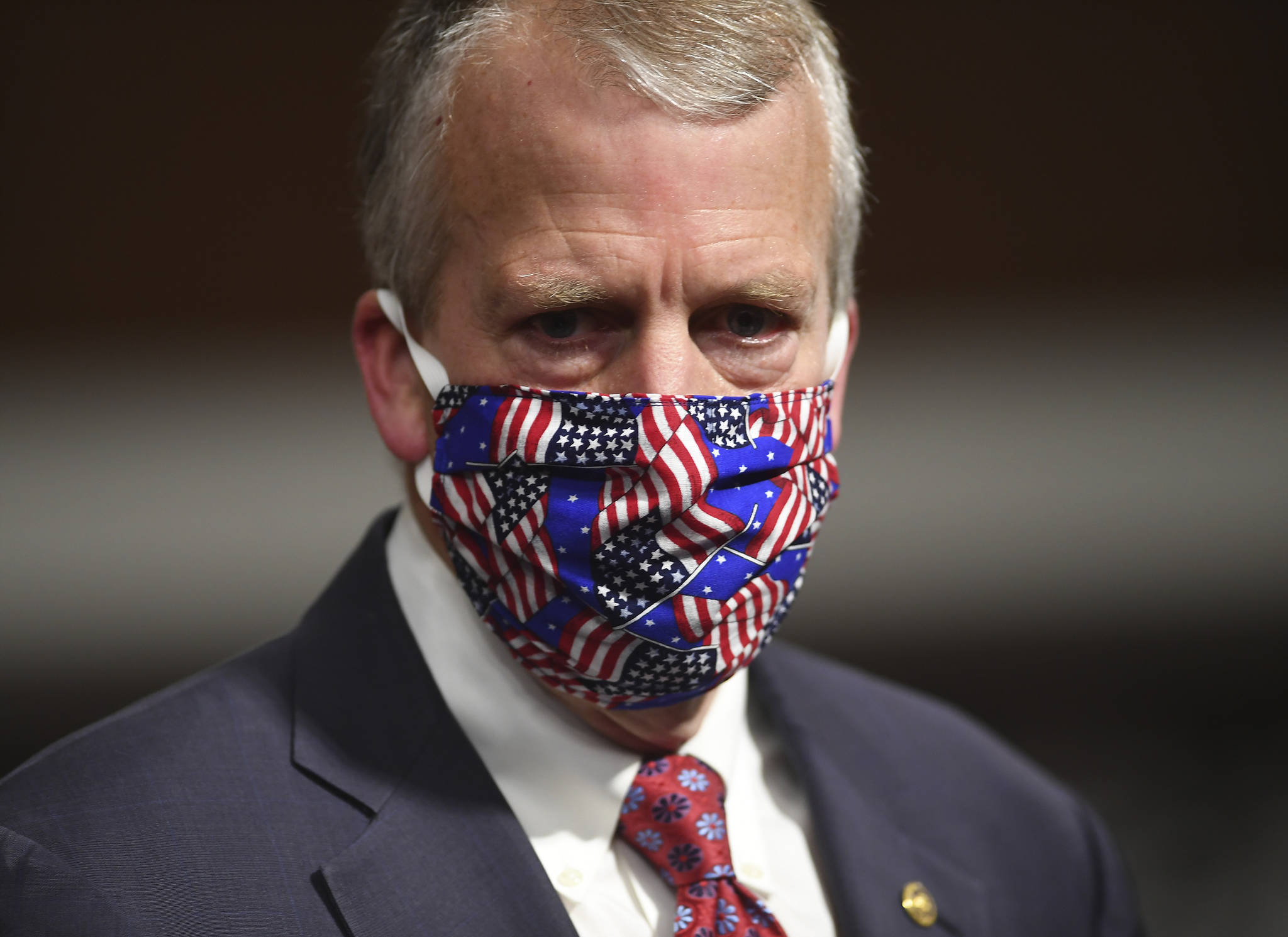 In this May 7 photo, Sen. Dan Sullivan wears a mask at a hearing in Washington. Protesters in Alaska carrying a banner and a caribou heart interrupted a campaign event for Sullivan who is seeking reelection. The Anchorage Daily News reported the small group of protesters were restrained and escorted out by staff and attendees at Sullivan’s campaign launch event in a hangar near Ted Stevens Anchorage International Airport, Saturday, July 11. (Kevin Dietsch/Pool via AP, File)