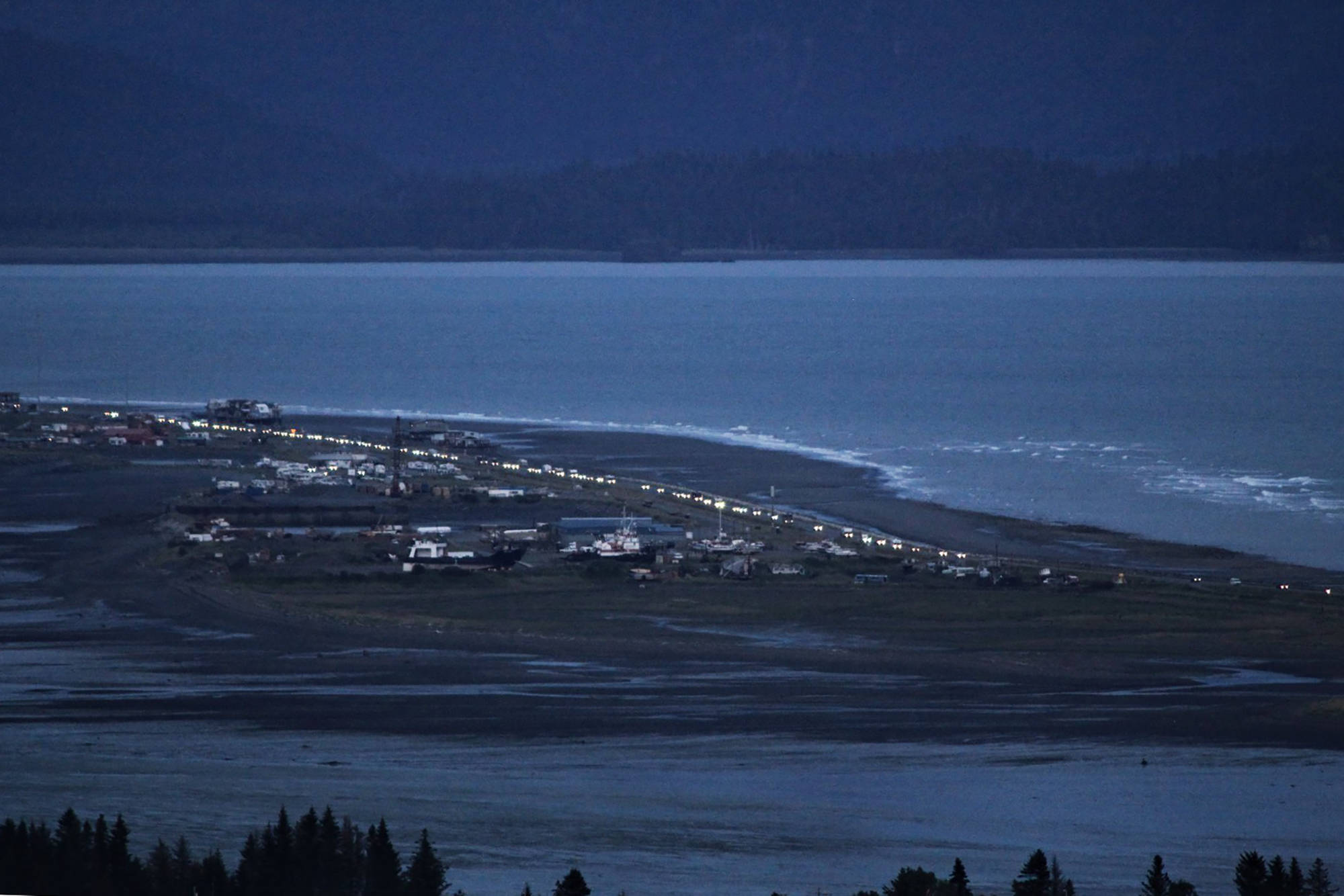 Headlights from a line of cars shine at dusk as people evacuate the Spit in Homer, Alaska, following a powerful earthquake in the Aleutian Islands that prompted a tsunami warning. There were no immediate reports of damage in the sparsely populated area of the state, and the tsunami warning was later canceled. (Pat Williams Russell)