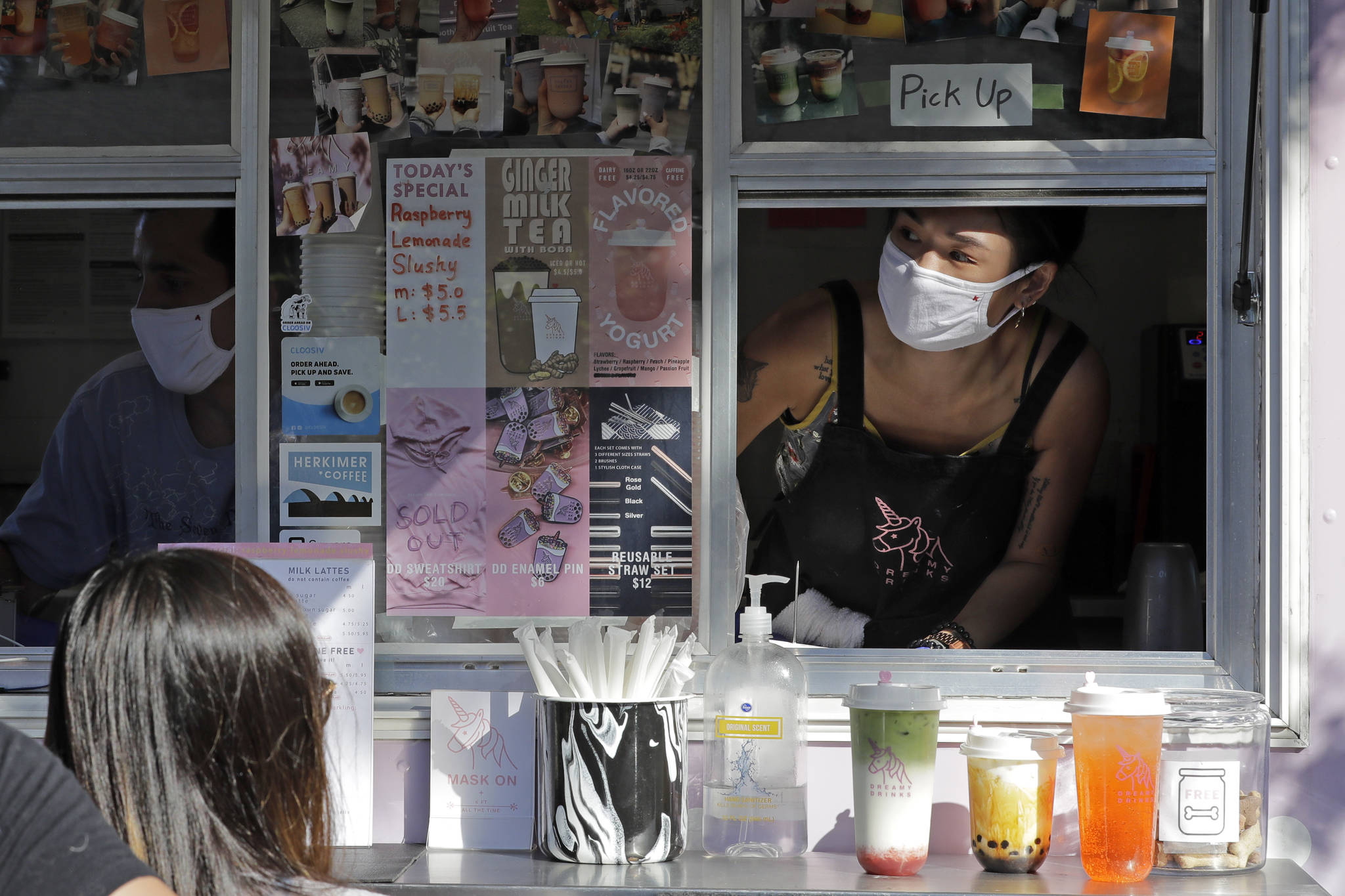 Kaye Fan, right, calls out orders as she works in her Dreamy Drinks food truck, Monday, Aug. 10, 2020, near the suburb of Lynnwood, Wash., north of Seattle. Long seen as a feature of city living, food trucks are now finding customers in the suburbs during the coronavirus pandemic as people are working and spending most of their time at home. (AP Photo / Ted S. Warren)