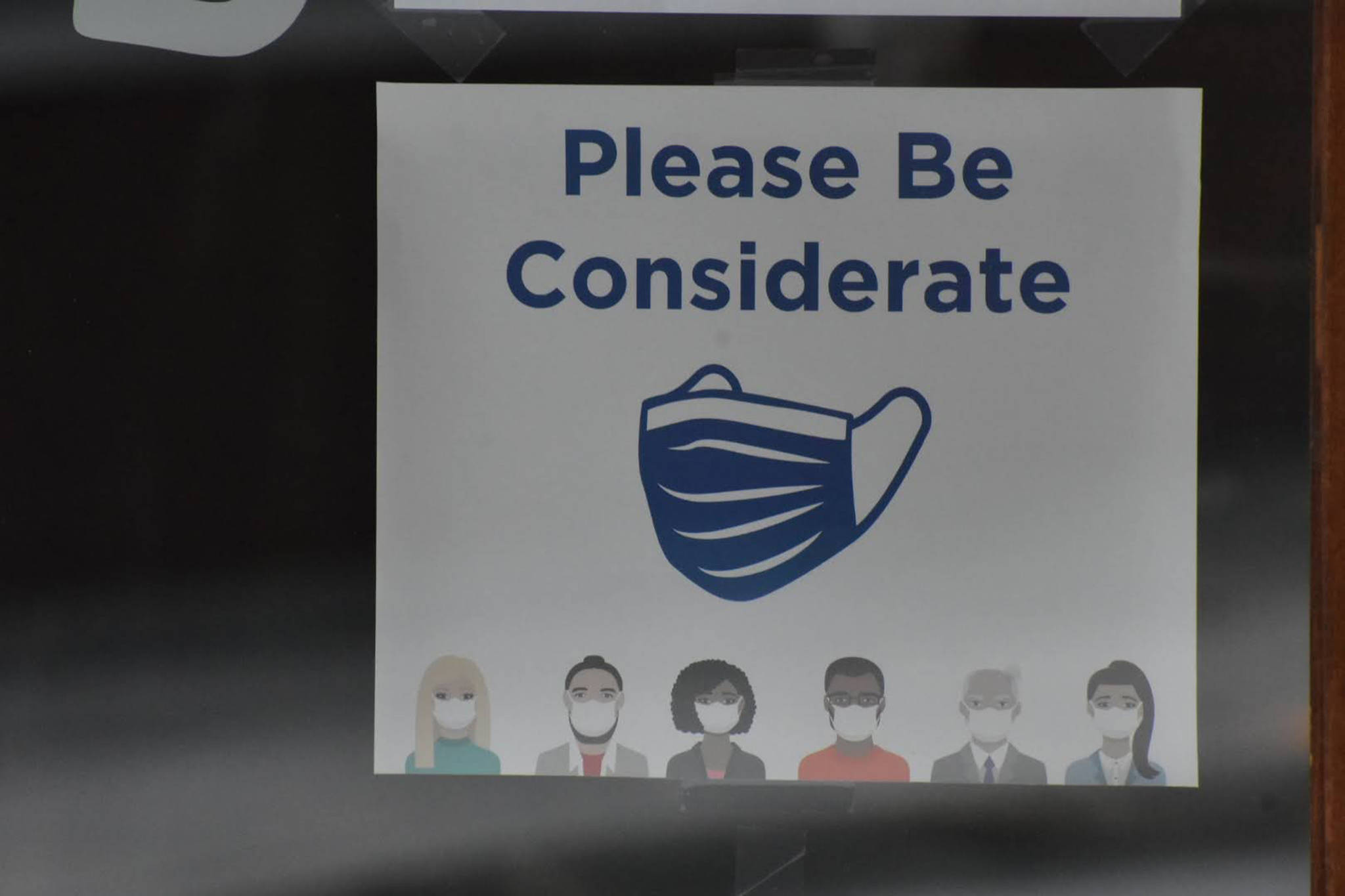 Signage displayed downtown encourages people to wear face coverings. City officials asked for conscientiousness and residents to take precautions to limit spread of COVID-19 amid the implementation of new spread mitigation measures that include limiting the capacity of bars and gyms and the size of social gatherings. (Peter Segall / Juneau Empire File)