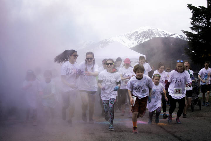 Runners jog through a haze of colored powder as they begin a 5k run through downtown Juneau on Sunday, April 29, 2018. (Richard McGrail / Juneau Empire File)