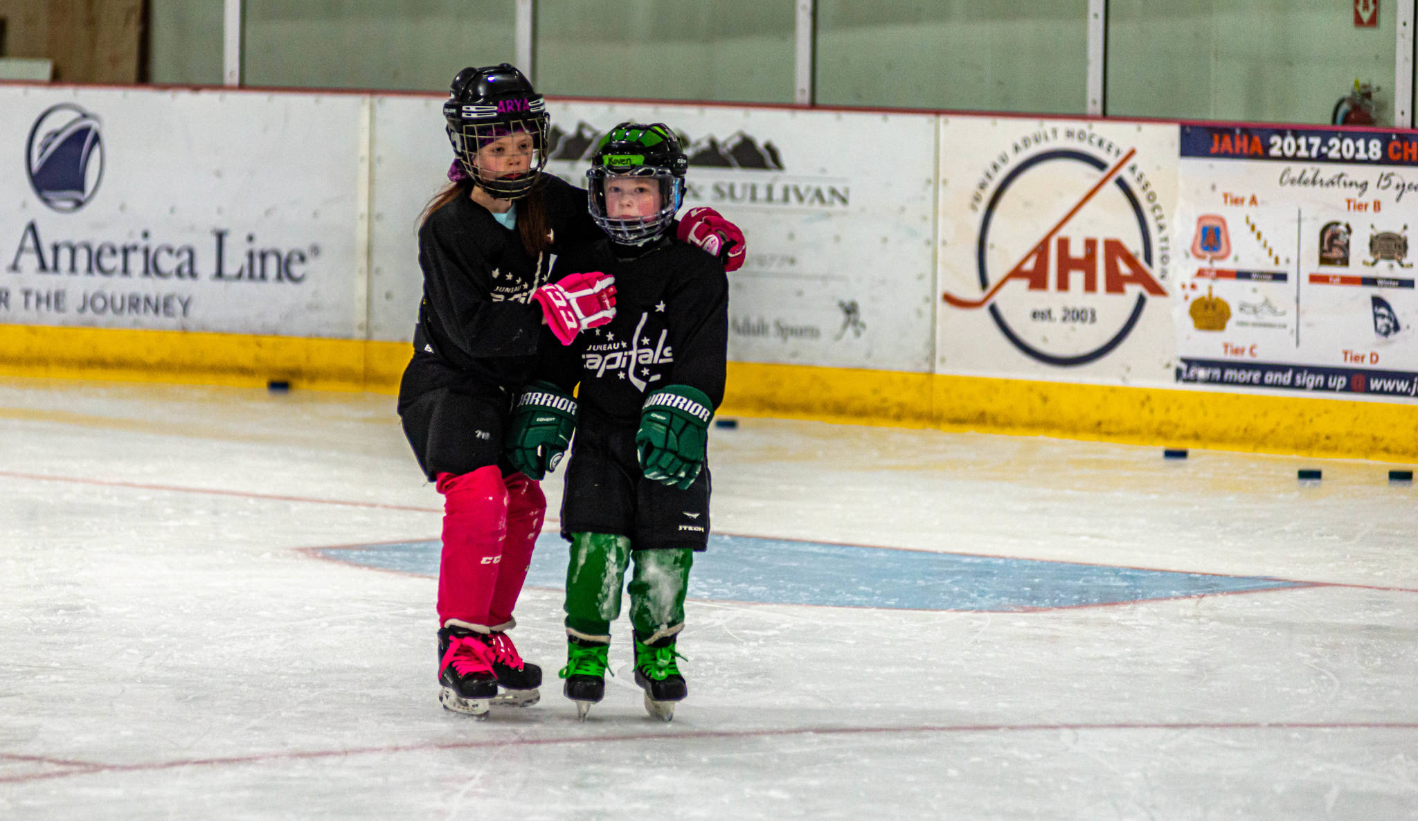 Bonds quickly form between two players participating in the 8-and-under age group at Treadwell Ice Arena. (Courtesy Photo / Steve Quinn)