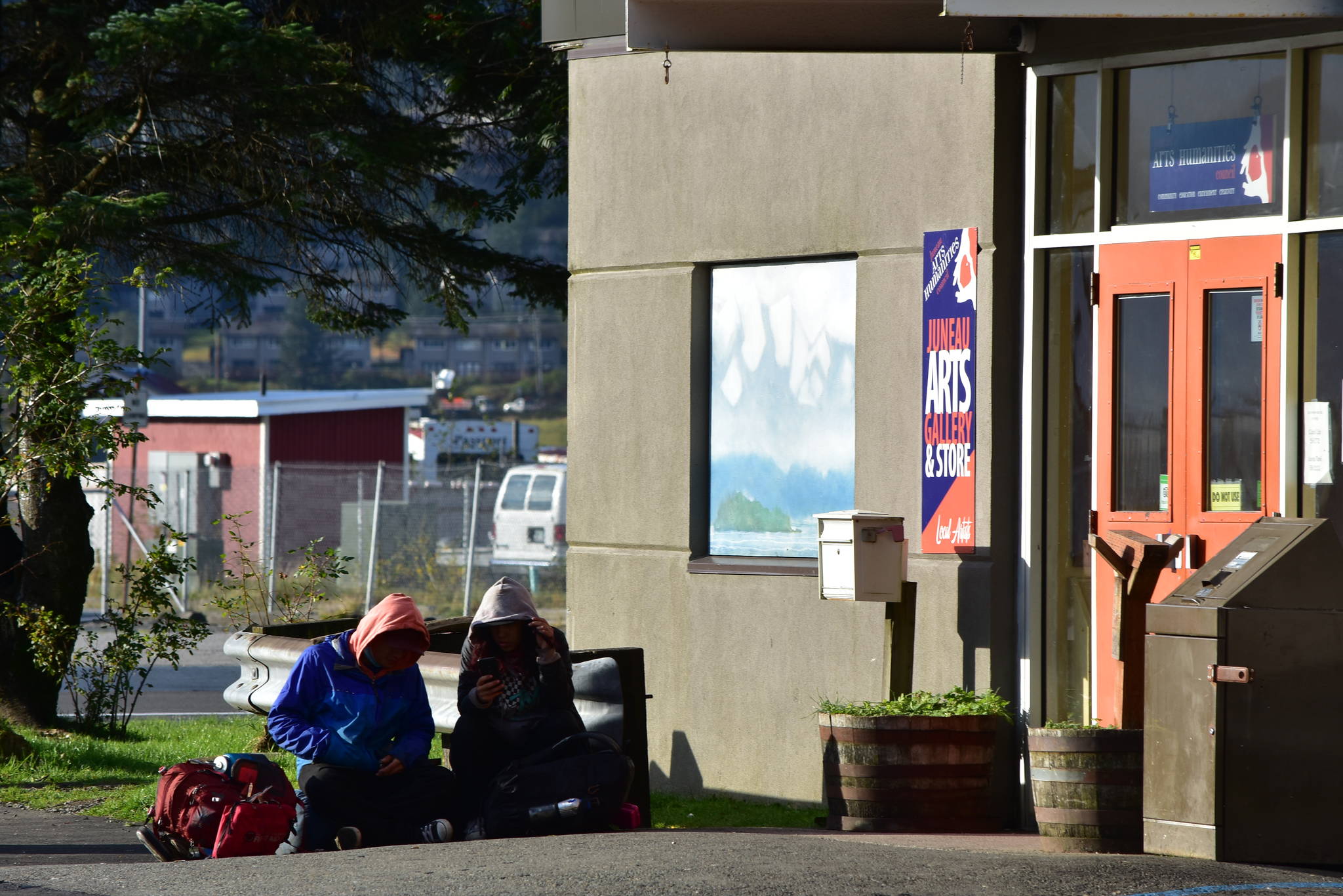People sit outside the Juneau Arts & Culture Center on Tuesday, Sept. 15. The JACC is poised to serve as an emergency warming shelter through the first quarter of next year. (Peter Segall / Juneau Empire)