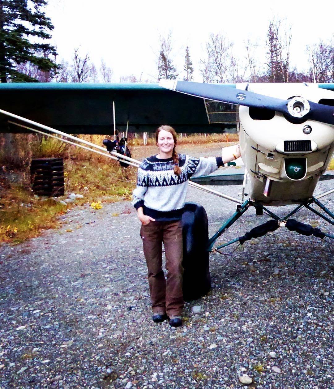 Tia Shoemaker, hunting guide and bush pilot on the Alaska Peninsula, stands next to her family’s plane.(Courtesy Photo / Tia Shoemaker)