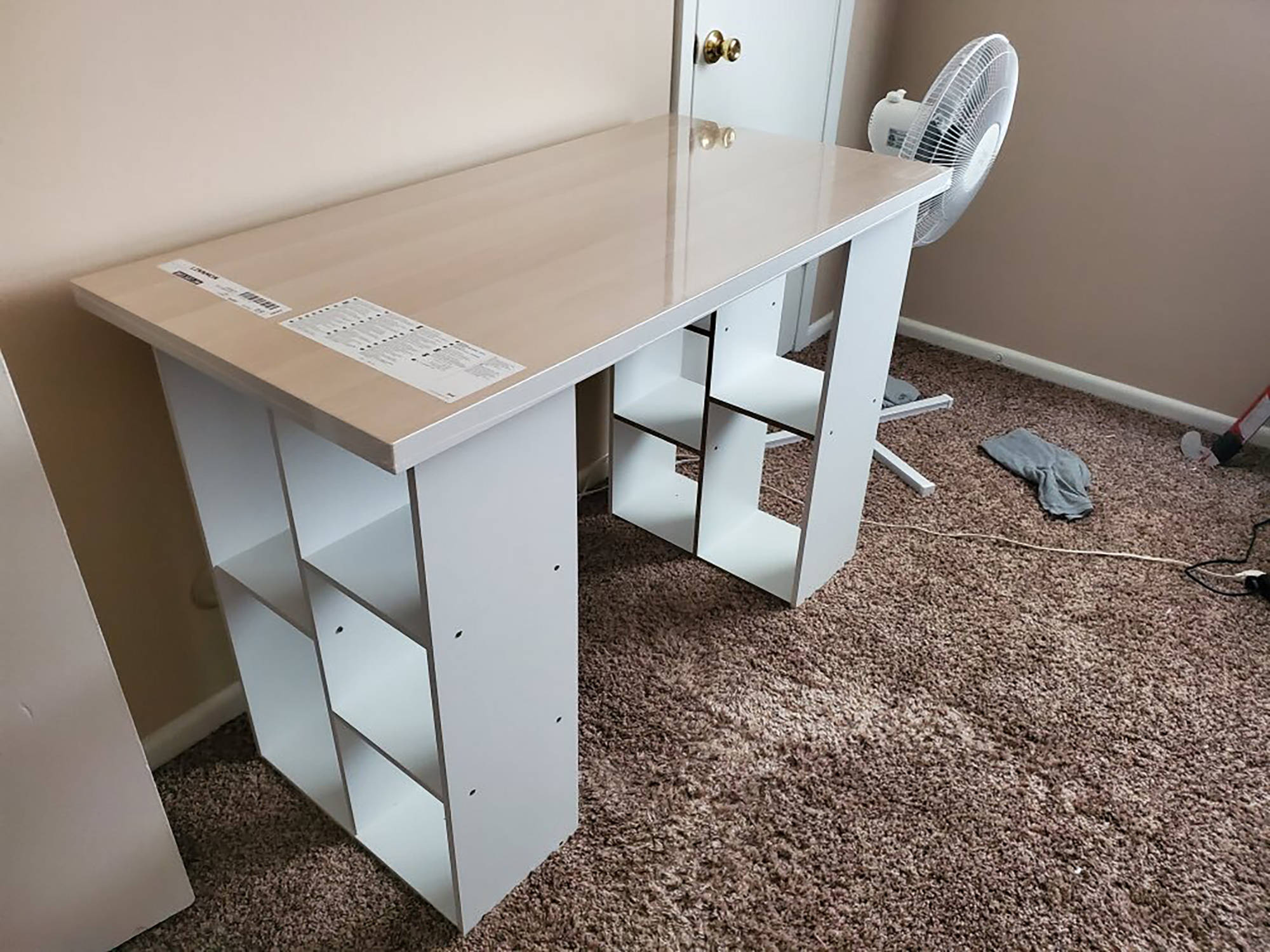 In this photo provided by Megan Fry, a desk Fry constructed out of a legless tabletop and bookcases stands in her Indianapolis home on Sept. 14, 2020. First it was toilet paper. Disinfectant wipes. Beans. Coins. Computers. Now, desks are in short supply because of the coronavirus pandemic. “It’s not as cute or trendy as a bought desk and I wish it had drawers for storage,” said Fry, who is starting a new work-from-home customer service job in Indianapolis in October. “But I’m happy it’s clean and has a large surface on top for my monitors and laptop.” (Courtesy Photo / Megan Fry)