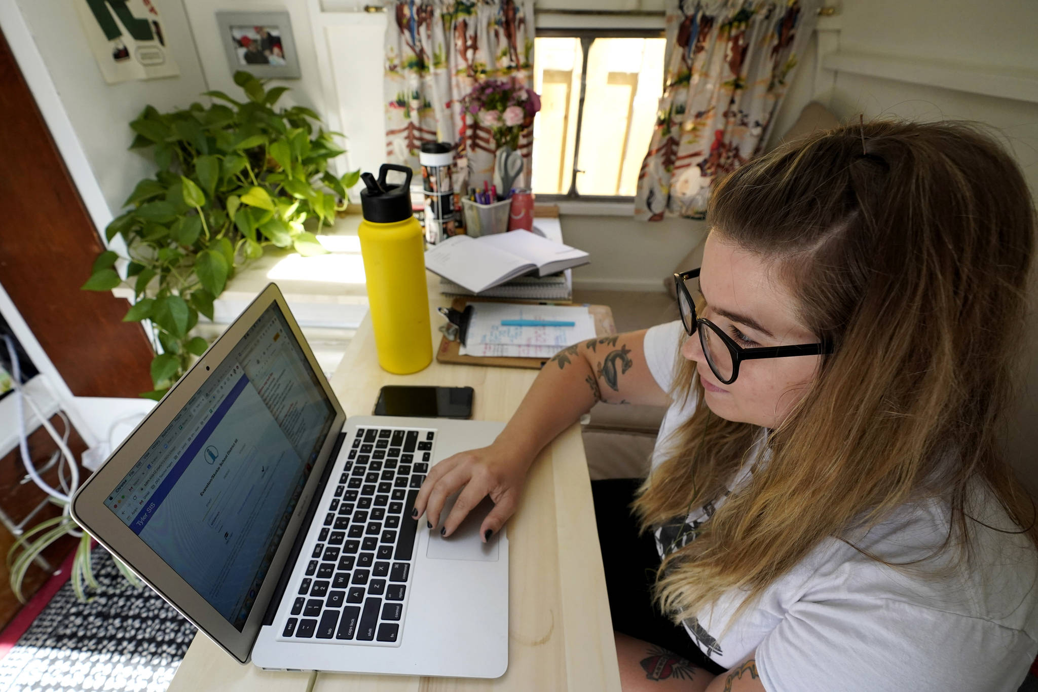 Kelly Mack works on her laptop to teach remotely from her early 1940s vintage camper/trailer in her backyard at home in Evanston, Ill. Across the U.S., the pandemic has forced students to attend virtual school to prevent spread of the coronavirus. But the more we rely on technology, the bigger the consequences when gadgets or internet service let us down. (AP Photo / Nam Y. Huh)