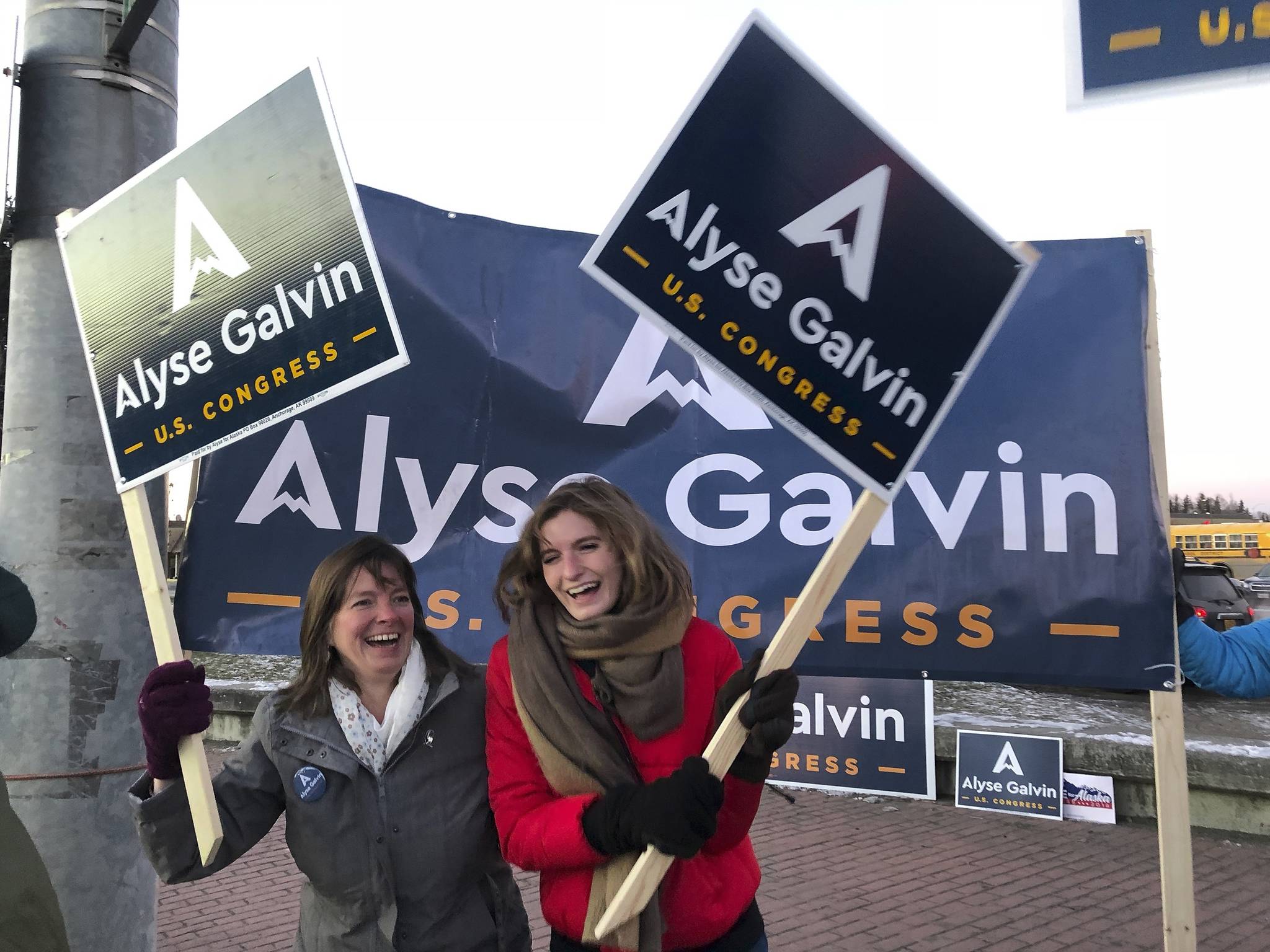 Alaska U.S. House candidate Alyse Galvin, left, and her daughter Bridget wave signs on the corner of a busy street in Anchorage in November 2018. Galvin, an Independent candidate, is challenging Republican U.S. Rep. Don Young. Young, the longest-ever serving Republican in the House, has not agreed to participate in many debates or forums this fall. “He’s dodging, he’s ducking debates because he’s afraid to talk the issues that Alaskans really care about most,” Galvin said Thursday, Oct. 1, 2020, of her 87-year-old opponent who has been in office since 1973. (AP Photo / Becky Bohrer)