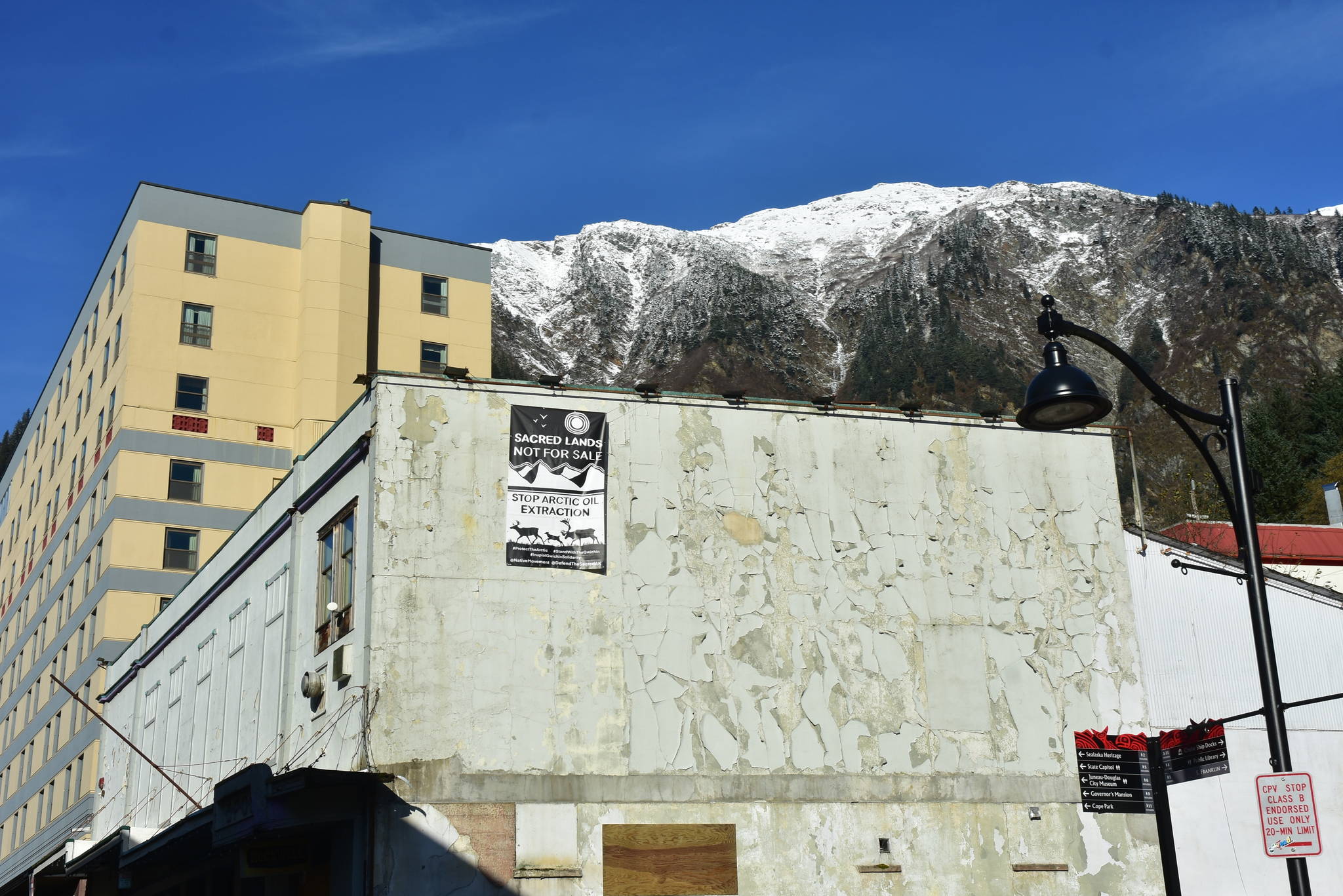 A banner protesting resource extraction in the Arctic was hung from a building in downtown Juneau on Wednesday, Oct. 21, 2020. Similar banners were hung in cities around the state and nation, part of a protest mounted by Alaska Native activists. (Peter Segall / Juneau Empire)