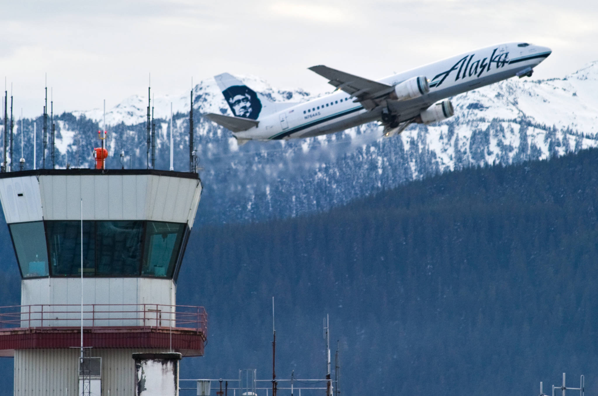 An Alaska Airlines cargo/passenger jet lifts off from the Juneau International Airport in this December 2014 photo. (Michael Penn / Juneau Empire FIle)