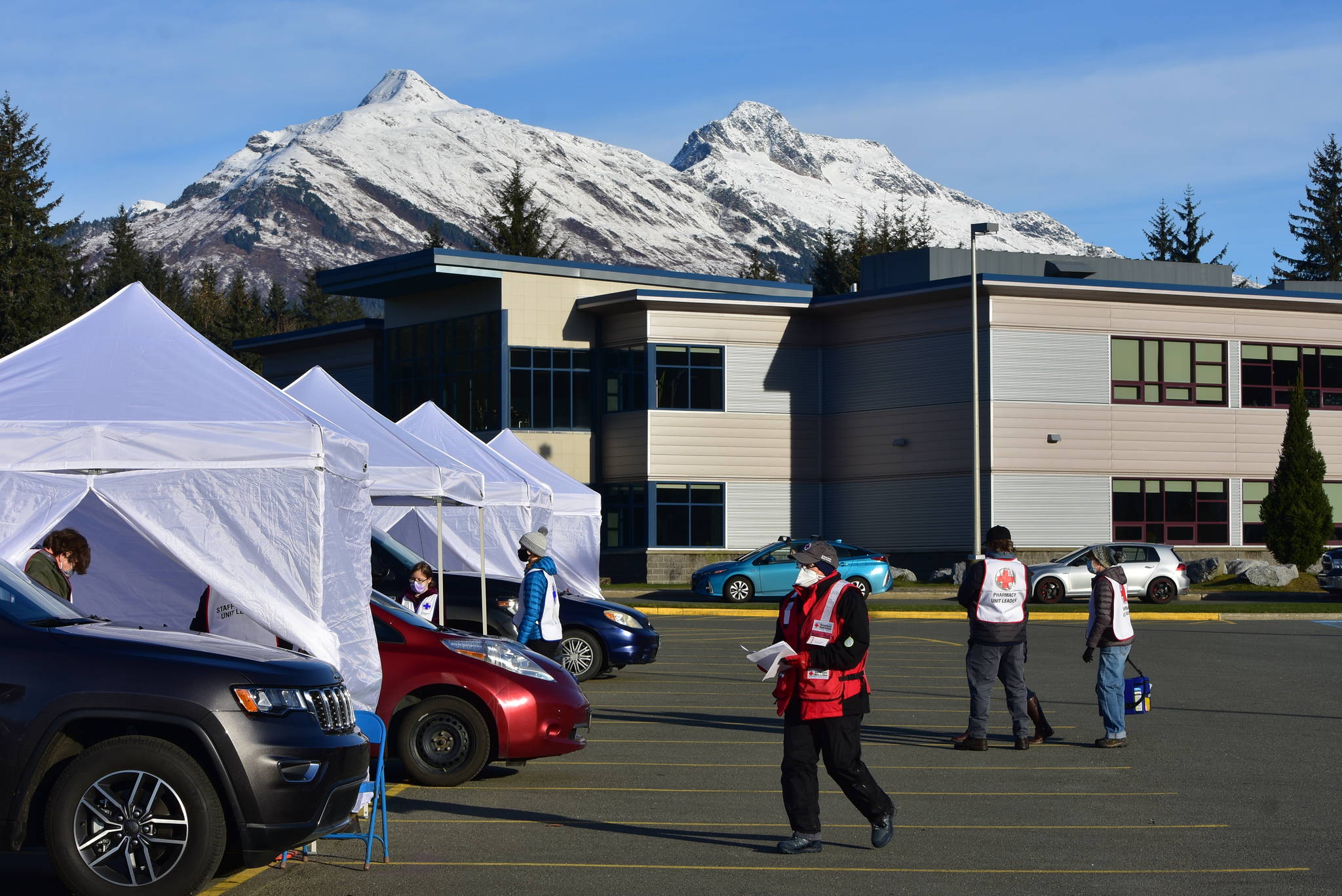 Several tents were set up for health workers and volunteers to guide hundreds of cars through drive-thru flu shot clinics at Thunder Mountain High School on Saturday, Oct. 24, 2020. A collaboration between state and local authorities, health officials set up the clinic to mass vaccinate Juneauites as an additional deterrent against the spread of the coronavirus. (Peter Segall / Juneau Empire)