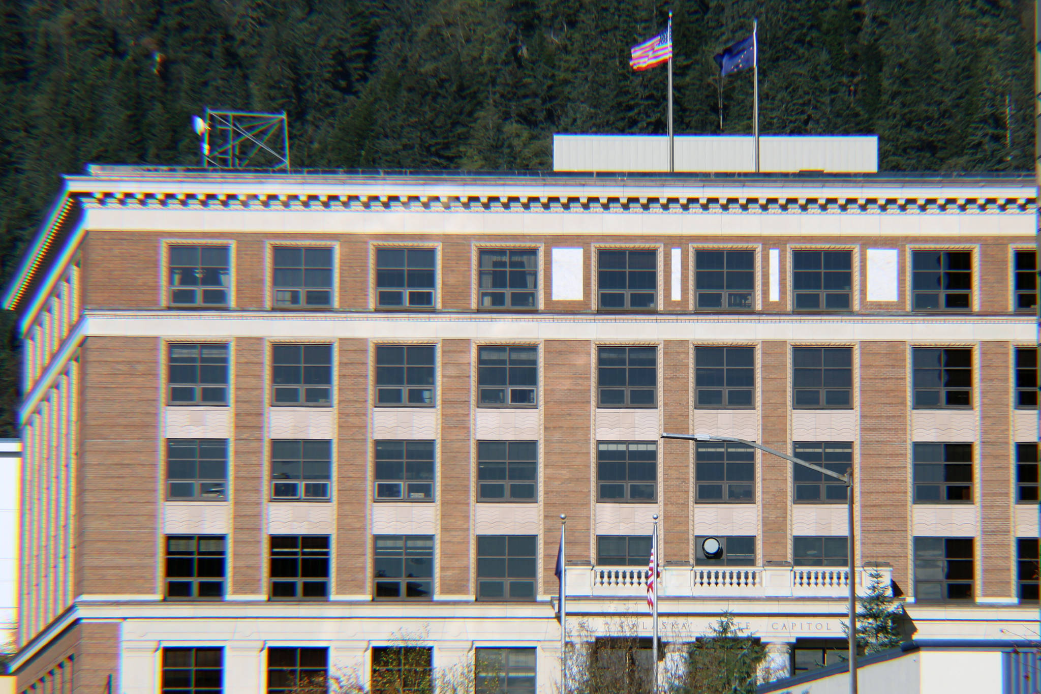 The U.S. Flag and Alaska state flag fly on the roof of the Alaska State Capitol on Saturday, Oct. 17, 2020. (Ben Hohenstatt / Juneau Empire)