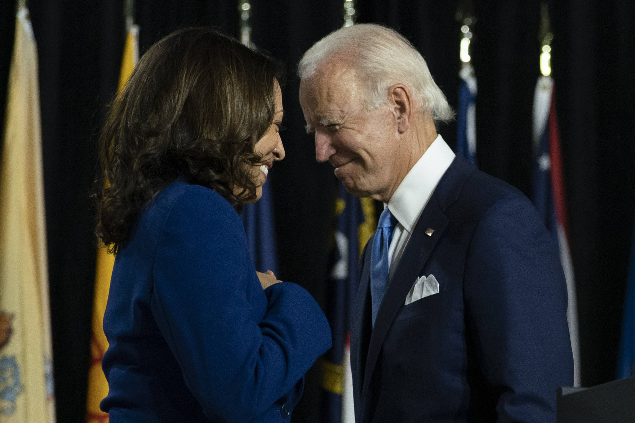 Democratic presidential candidate former Vice President Joe Biden and his running mate Sen. Kamala Harris, D-Calif., pass each other as Harris moves to the podium to speak during a campaign event at Alexis Dupont High School in Wilmington, Del. Harris made history Saturday, Nov. 7, as the first Black woman elected as vice president of the United States, shattering barriers that have kept men — almost all of them white — entrenched at the highest levels of American politics for more than two centuries. (AP Photo / Carolyn Kaster)