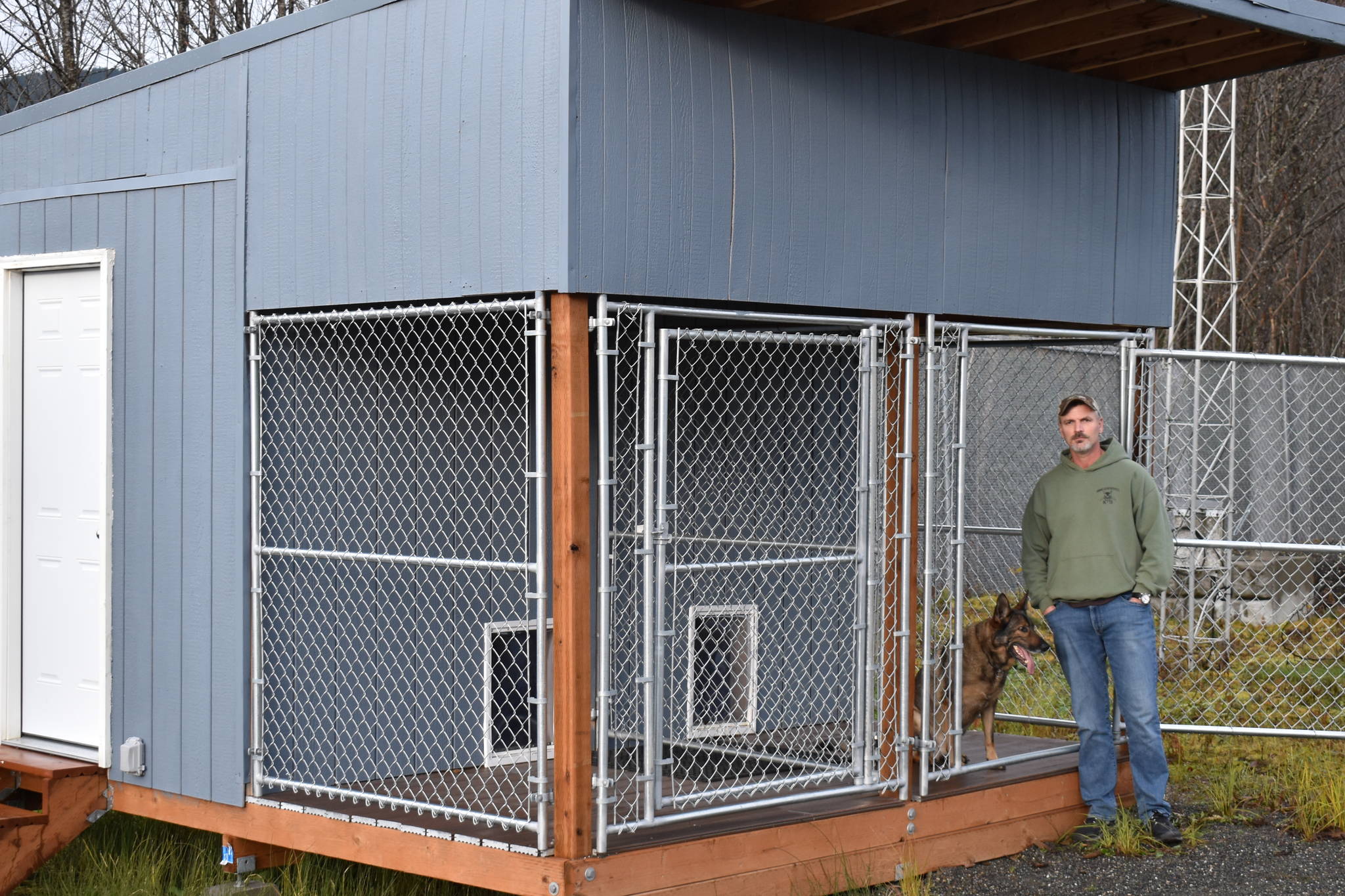 Juneau Police Department narcotics dog Buddy and handler Officer Mike Wise pose with Buddy’s new kennel, assembled with funds raised by the Juneau Crime Line. (Courtesy photo / Robin Paul)