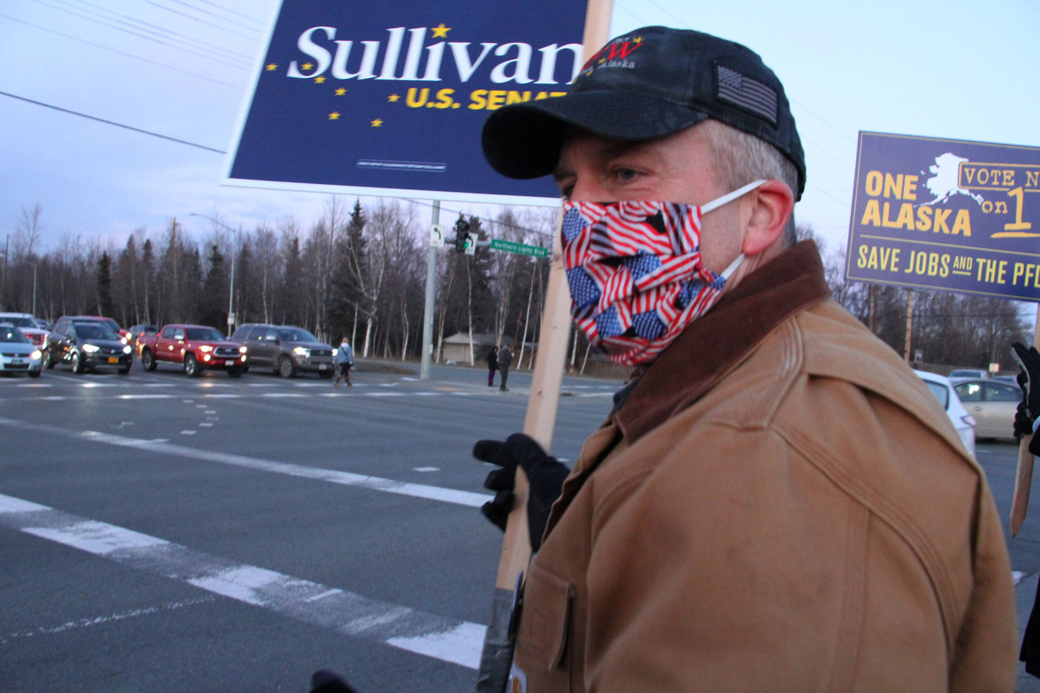 Republican U.S. Sen. Dan Sullivan waves a sign at a busy intersection in Anchorage, Alaska. Sen. Sullivan on Wednesday, Nov. 11, 2020, won reelection in Alaska, defeating independent Al Gross. (AP Photo / Mark Thiessen)