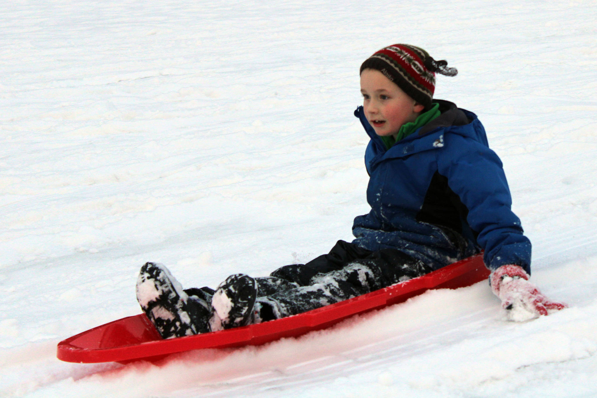 Alex Weiss, 9, sleds down a hill at Twin Lakes Friday, Nov. 20. (Ben Hohenstatt / Juneau Empire)