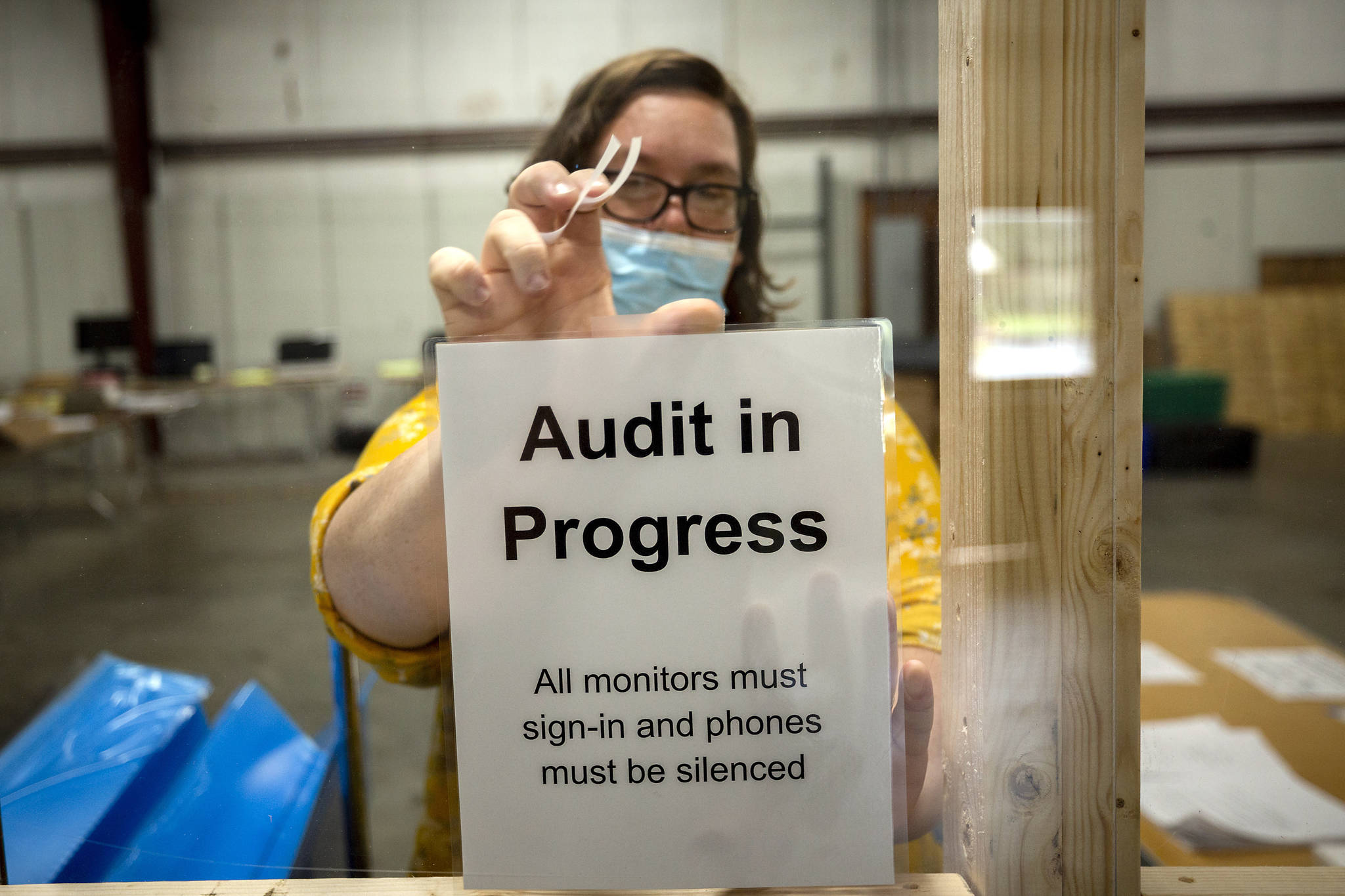 A Chatham County election official posts a sign in the public viewing area before the start of a ballot audit, Friday, Nov. 13, 2020, in Savannah, Ga. Election officials in Georgias 159 counties are undertaking a hand tally of the presidential race that stems from an audit required by state law. (AP Photo / Stephen B. Morton)