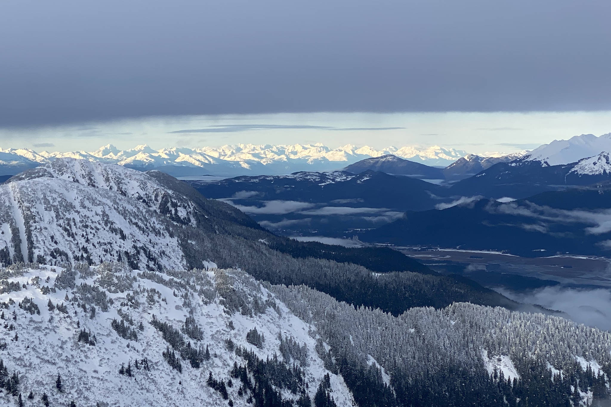 The Chilkat Mountains glow brightly in the distance as seen from the summit of Jumbo on Nov. 24. (Courtesy Photo / Robert Sauerteig)