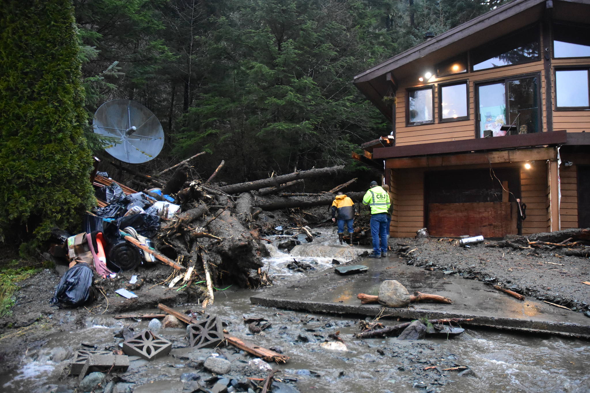 A mudslide at the top of Wire Street near Twin Lakes Wednesday, Dec. 2, 2020, sent rocks and other debris down the road. City and Borough of Juneau staff were on-site to assess the damage. (Peter Segall / Juneau Empire)