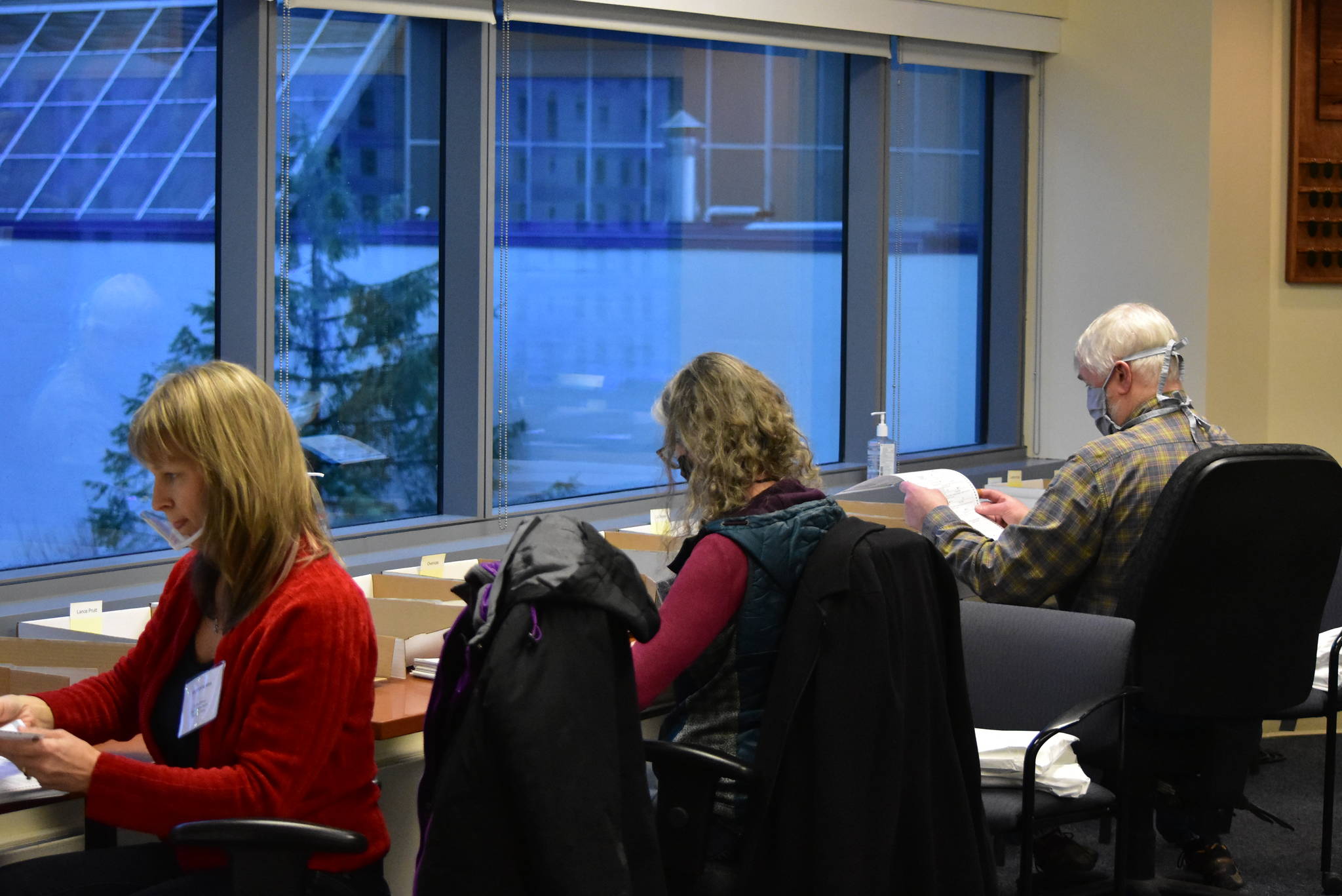 Members of the State Review Board hand count ballots from Anchorage's House District 27 on Friday, Dec. 4,  2020. The race was called with a margin of only 13 votes, and a recount was requested shortly after results were certified. (Peter Segall / Juneau Empire)