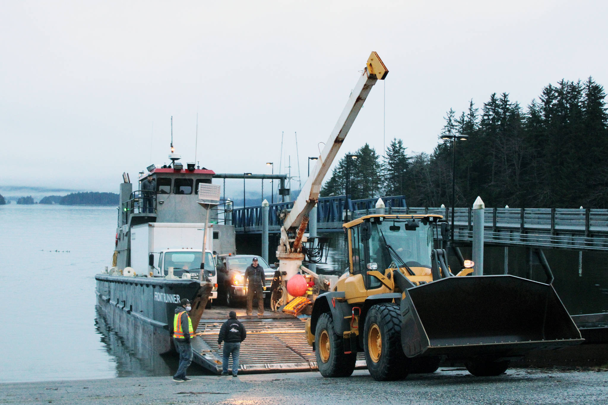 Personnel from the Central Council Tlingit and Haida Indian Tribes of Alaska load a front-end loader aboard the vessel Frontrunner for transit to Haines to provide relief and assistance in recovery efforts in Haines following catastrophic rainfall-fueled landslides, Dec. 3, 2020. (Ben Hohenstatt / Juneau Empire)
