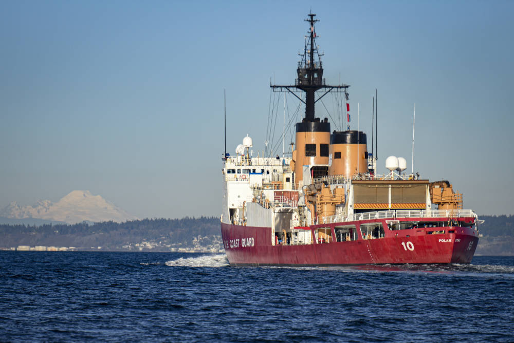 With Mt. Baker in the background, U.S. Coast Guard Cutter Polar Star (WAGB-10) transits Puget Sound north of Seattle on Dec. 4, 2020. The Alaska Navy League is holding a drive for the servicemembers aboard as they’re deployed during the winter holidays. (Petty Officer 2nd Class Steve Strohmaier / U.S. Coast Guard)