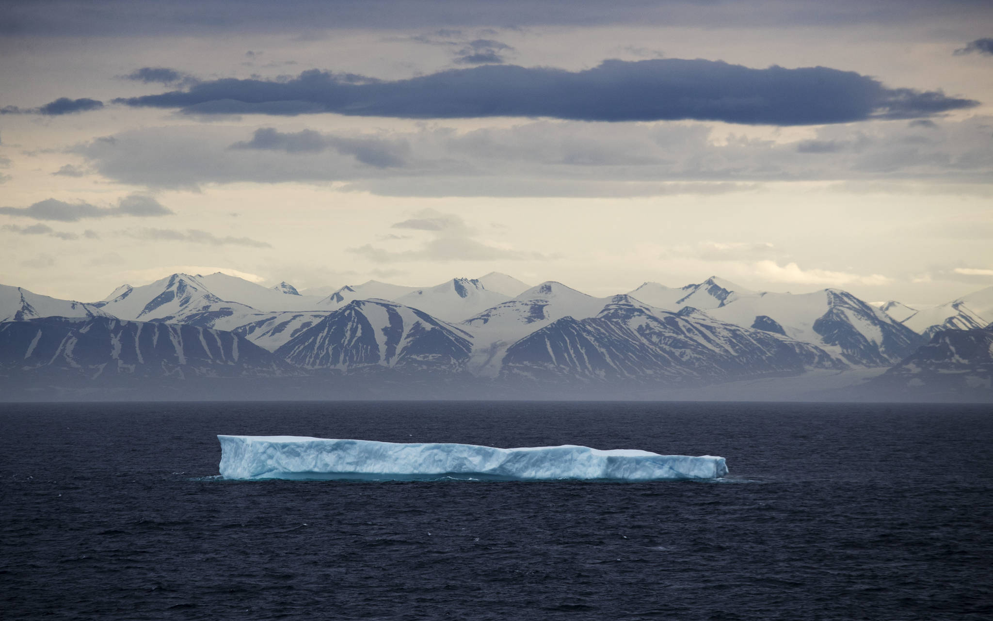 An iceberg floats past Bylot Island in the Canadian Arctic Archipelago. The National Oceanic and Atmospheric Administration’s annual Arctic Report Card, released on Tuesday, Dec. 8, 2020, shows how warming temperatures in the Arctic are transforming the region’s geography and ecosystems. (AP Photo/David Goldman, File)