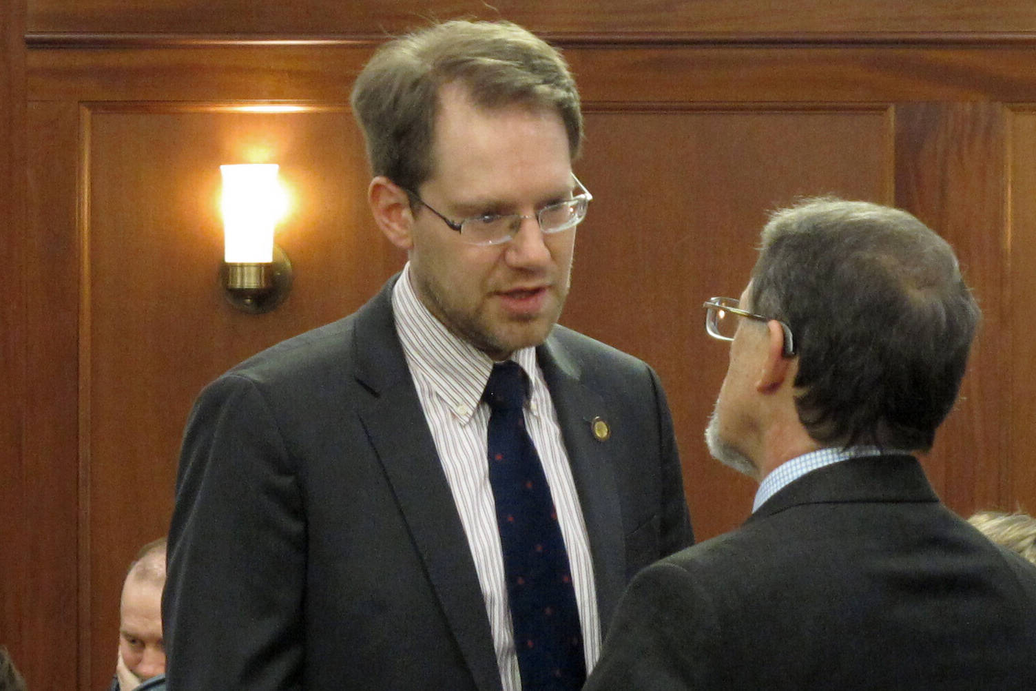 FILE - In this March 5, 2020 file photo, Alaska Republican House Minority Leader Lance Pruitt, left, speaks with Rep. George Rauscher on the floor of the House in Juneau, Alaska. Pruitt, of Anchorage, is challenging in court his 11-vote loss in a state House race to Democrat Liz Snyder. (AP Photo/Becky Bohrer, File)