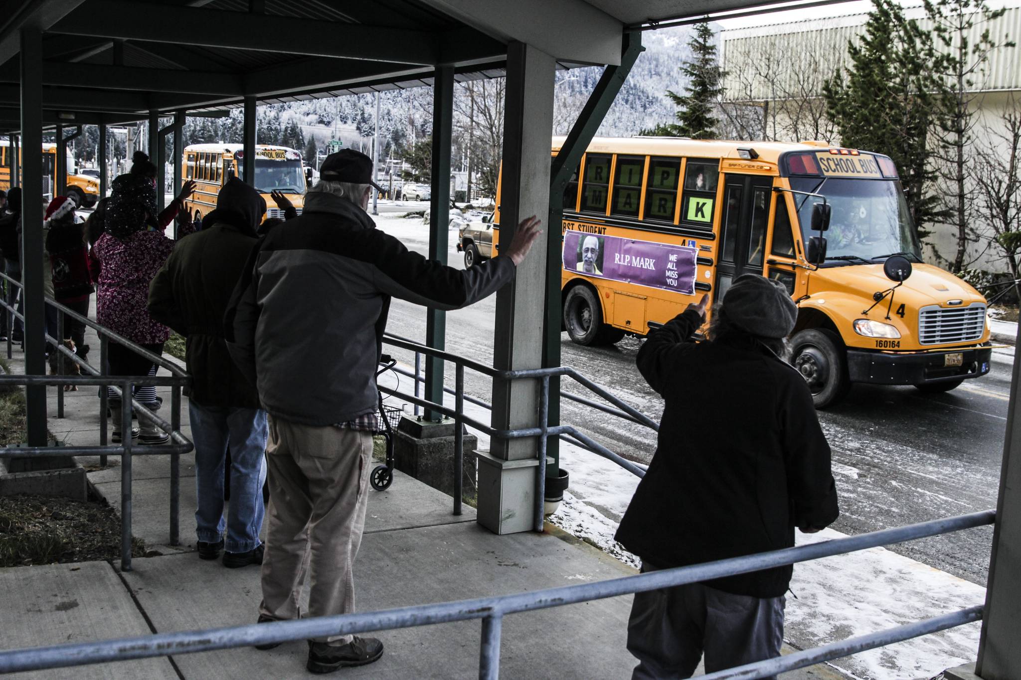 First Student Inc. held a bus parade Saturday to remember recently killed employee Mark Sateri, driving by the Mountain View Apartments where Sateri lived and died as residents came out to remember him, Dec. 12, 2020. (Michael S. Lockett / Juneau Empire)