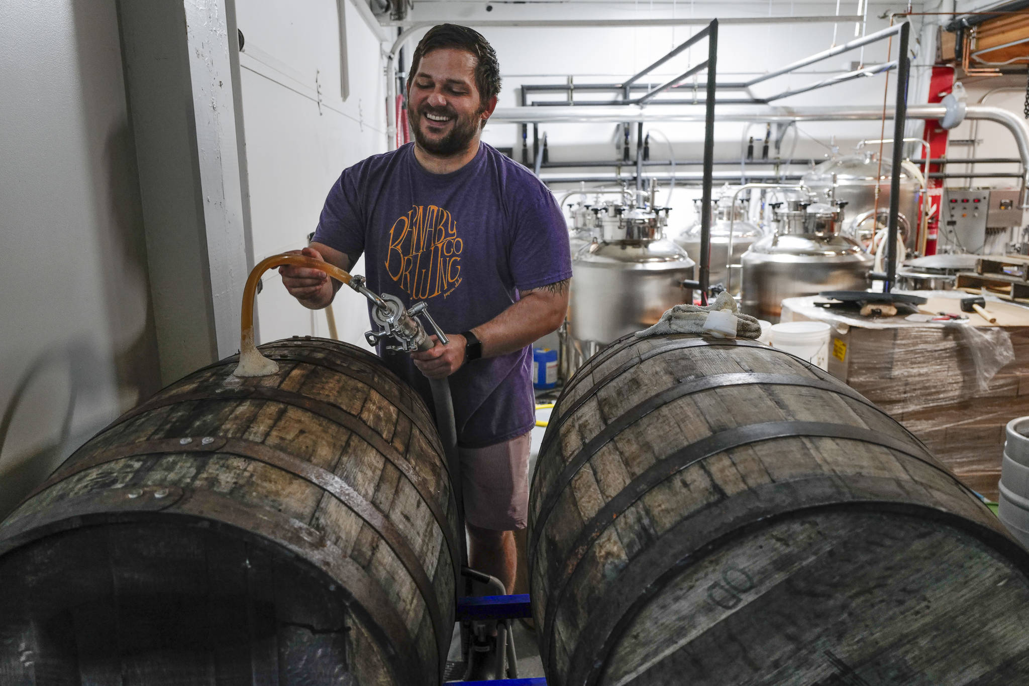 Matt Barnaby, co-owner and brewer at the Barnaby Brewing Company, works to fill wooden casks for a longer term beer project on Wednesday, Nov. 6, 2019.  (Michael Penn / Juneau Empire File)