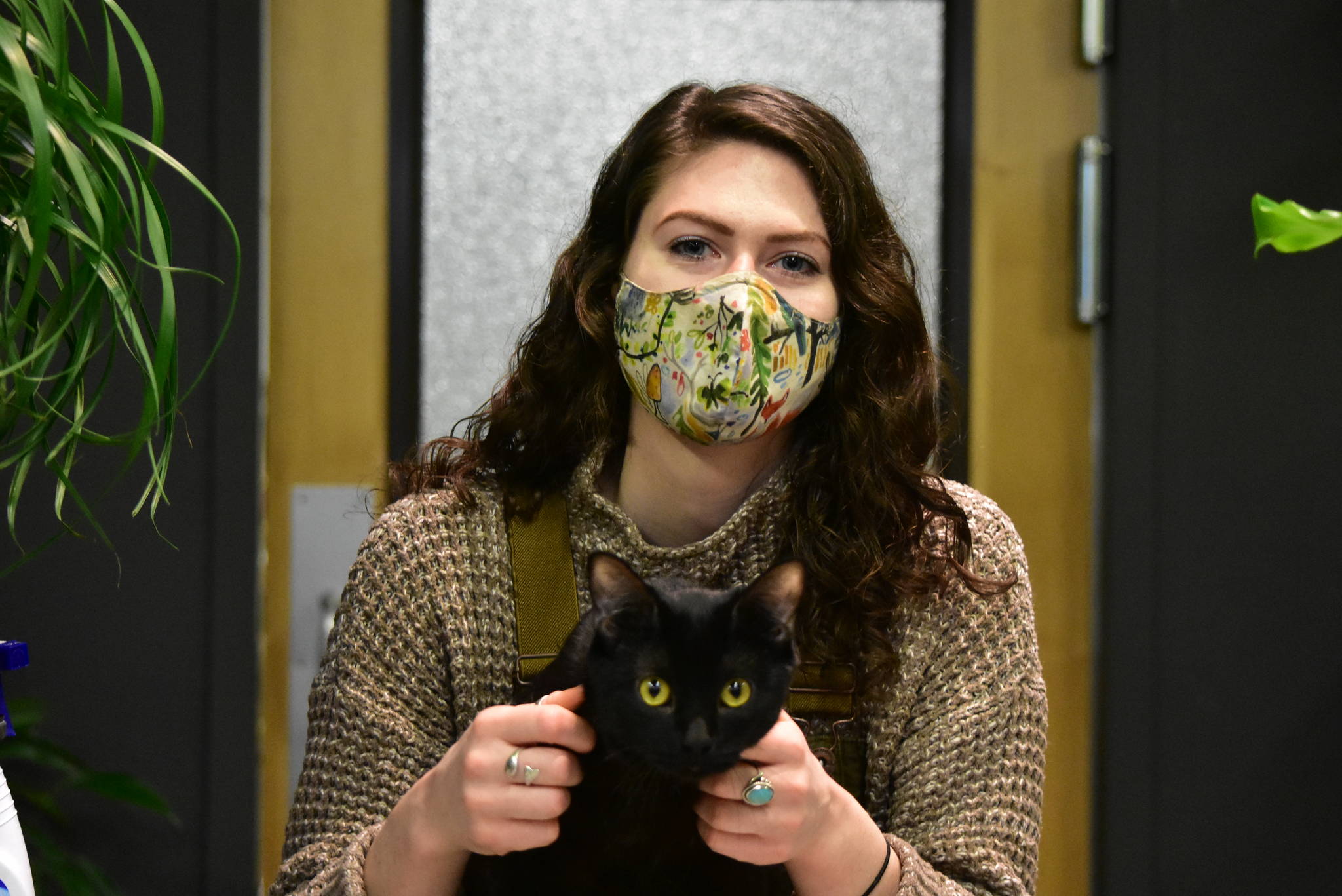 Morgan Johnson, owner of the Plant Studio in downtown Juneau with her cat Edgar on Tuesday, Dec. 15, 2020, said she thinks having people wear masks makes her customers more comfortable. (Peter Segall / Juneau Empire)