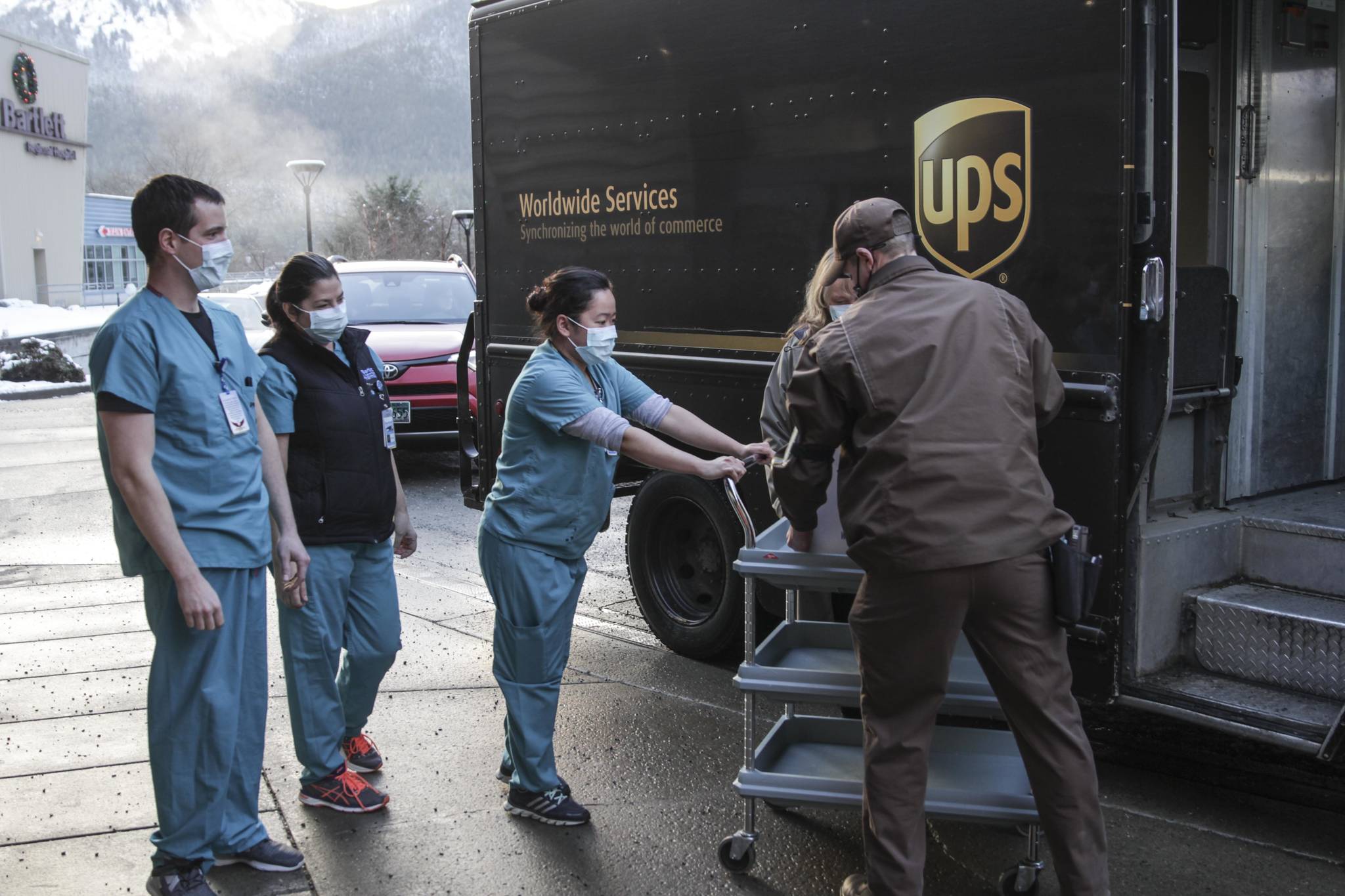 Michael S. Lockett / Juneau Empire 
Bartlett Regional Hospital pharmacy personnel Justin Richardson, Andrea Stats, Krischelle Batac, and Ursula Iha take delivery of the first shipment of the coronavirus vaccine from a UPS employee on Dec. 15, 2020. BRH immediately began vaccinating its personnel upon receipt of the vaccine.