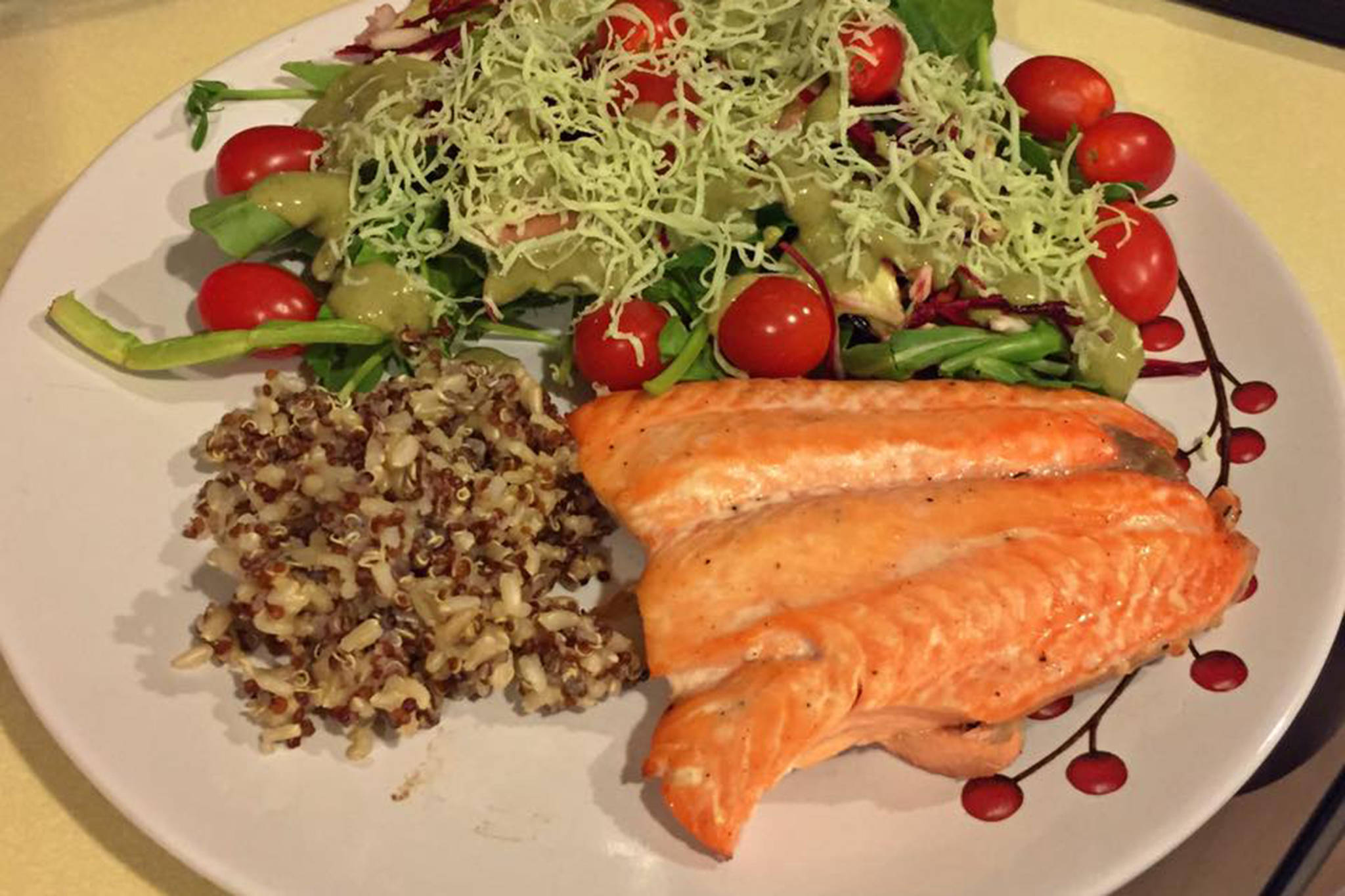 This photo shows salmon, quinoa and salad. (Vivian Mork Yéilk’ / For the Capital City Weekly)