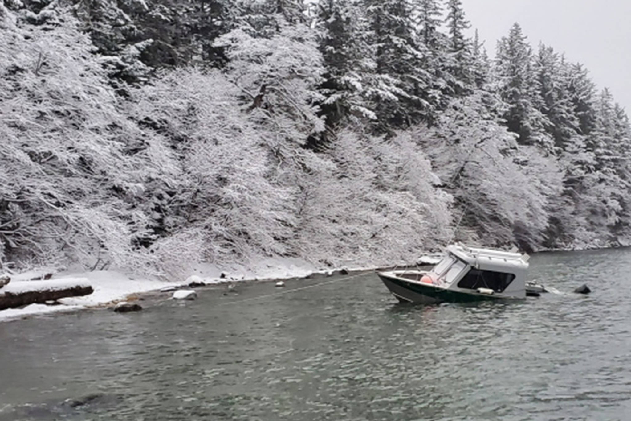A beached vessel is anchored to the shoreline in Barlow Cove, about 15 miles northeast of Juneau, Alaska, Dec. 17, 2020. The crew of Coast Guard cutter Bailey Barco rescued three hunters who ended up stranded on shore after the vessel took on water. (Courtesy Photo / U.S. Coast Guard Cutter Bailey Barco)