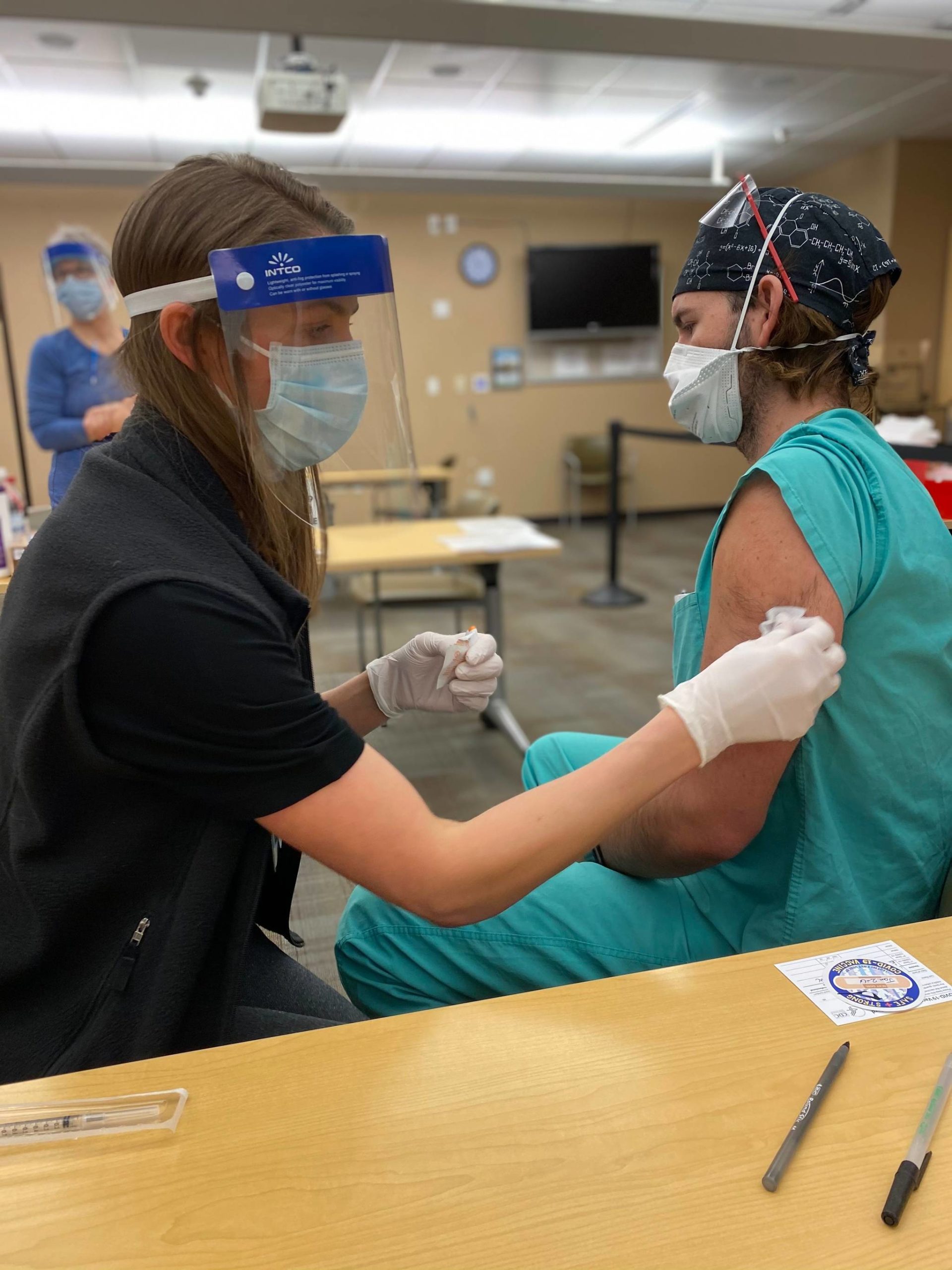 Pharmacist Katrina Green administers a COVID-19 vaccine to Justin Washburn, a CRNA student at Alaska Native Medical Center. (Courtesy Photo / Shirley Young, Alaska Native Tribal Health Consortium)