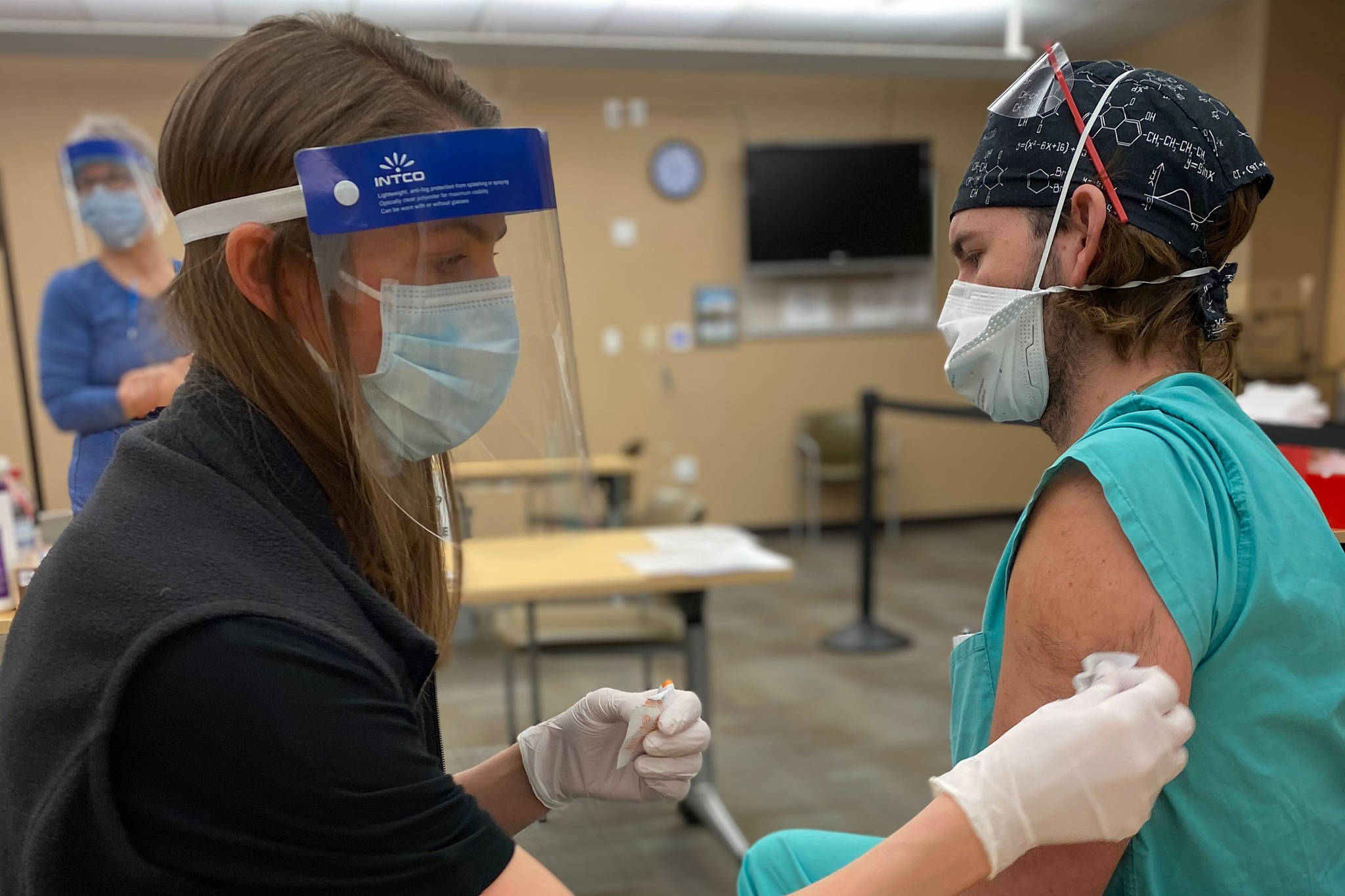 Pharmacist Katrina Green administers a COVID-19 vaccine to Justin Washburn, a CRNA student at Alaska Native Medical Center. (Courtesy Photo / Shirley Young, Alaska Native Tribal Health Consortium)