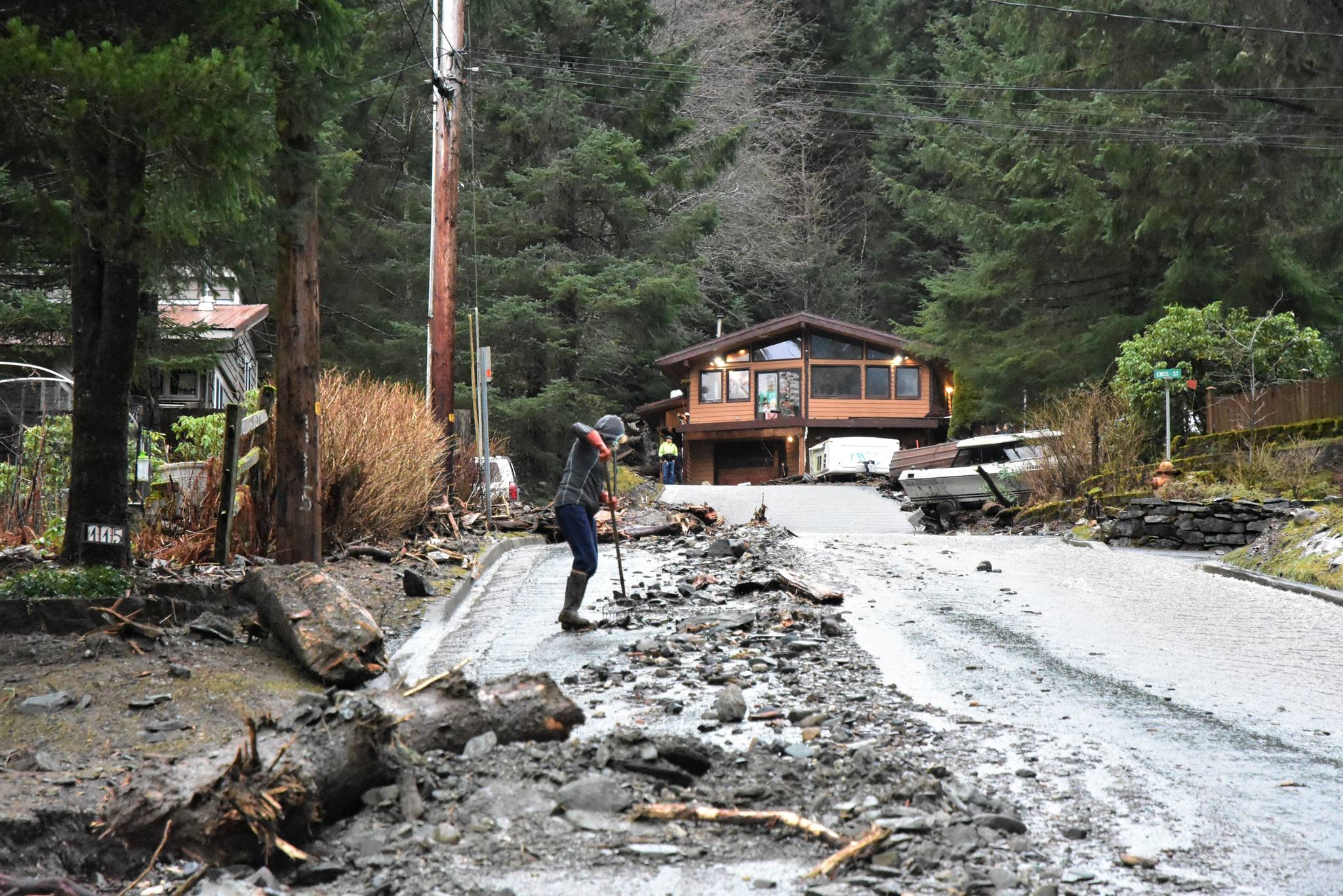 Residents on Wire Street near Twin Lakes clean up debris from a landslide caused by heavy rains on Dec. 2, 2020. The state of Alaska has set up a website to help people apply for state and federal relief money for damages caused by the storm. (Peter Segall / Juneau Empire file)