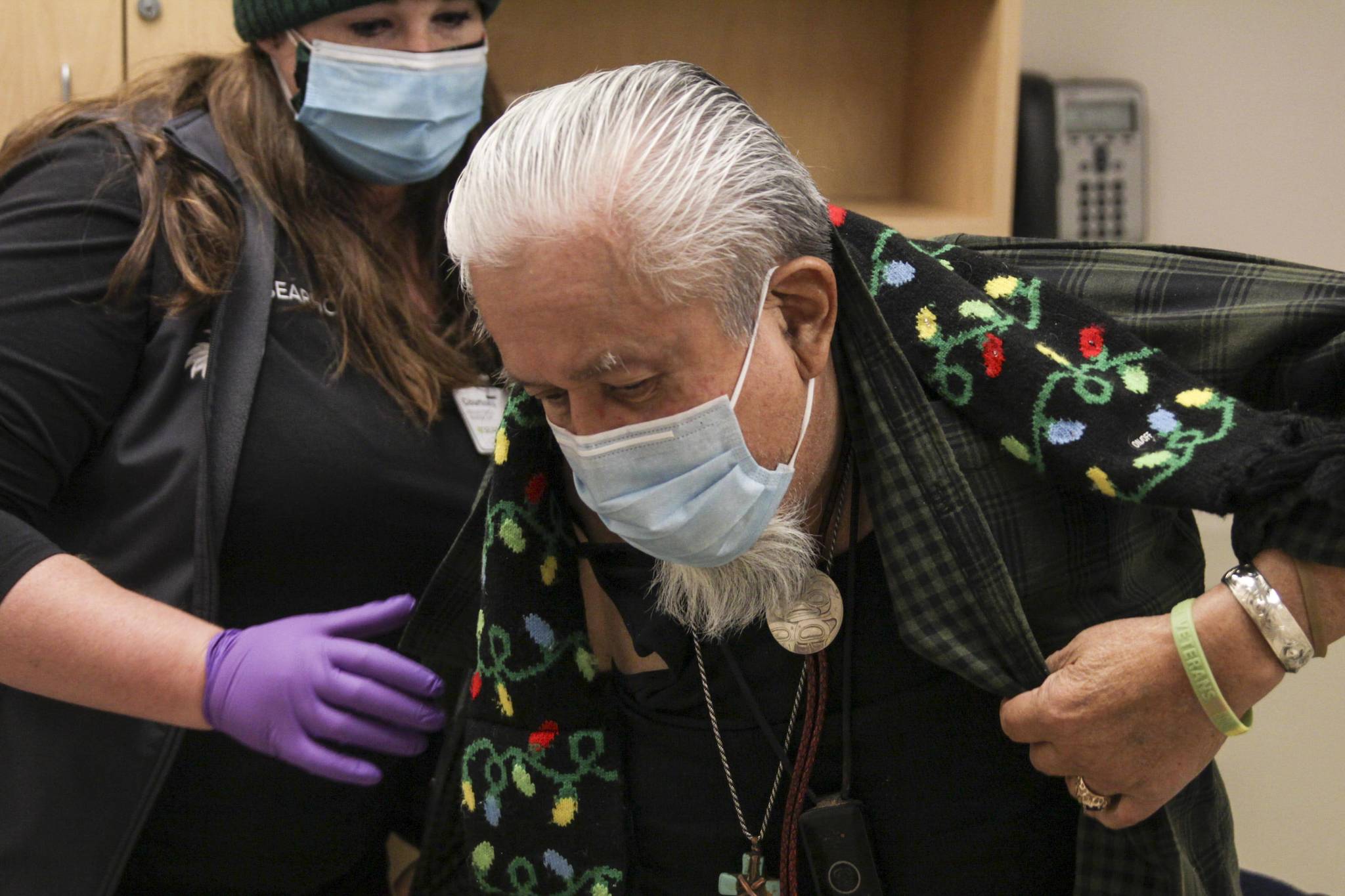 Southeast Alaska Regional Health Consortium nurse Courtney Taber helps Arsenio “Pastor” Credo as he prepares to receive the Moderna coronavirus vaccine at the Ethel Lund Medical Center on Dec. 24, 2020. The City and Borough of Juneau will be holding a clinic to vaccinate seniors and medical professionals at Centennial Hall, with registration beginning on Jan. 11, 2021. (Michael S. Lockett / Juneau Empire)